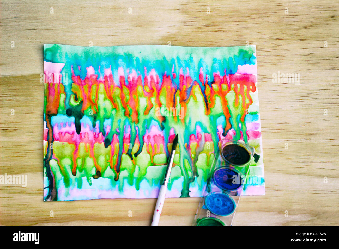 Foto von Aquarellfarbe und einem Pinsel auf einem Holztisch Stockfoto