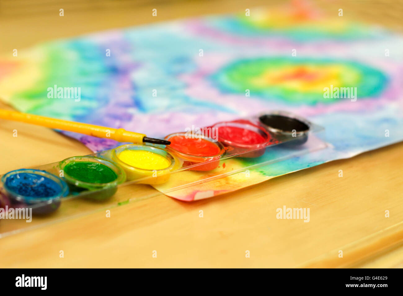 Foto von Aquarellfarbe und einem Pinsel auf einem Holztisch Stockfoto