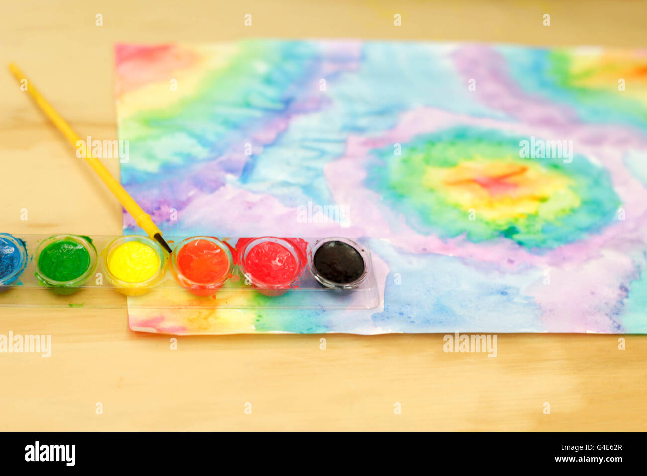 Foto von Aquarellfarbe und einem Pinsel auf einem Holztisch Stockfoto