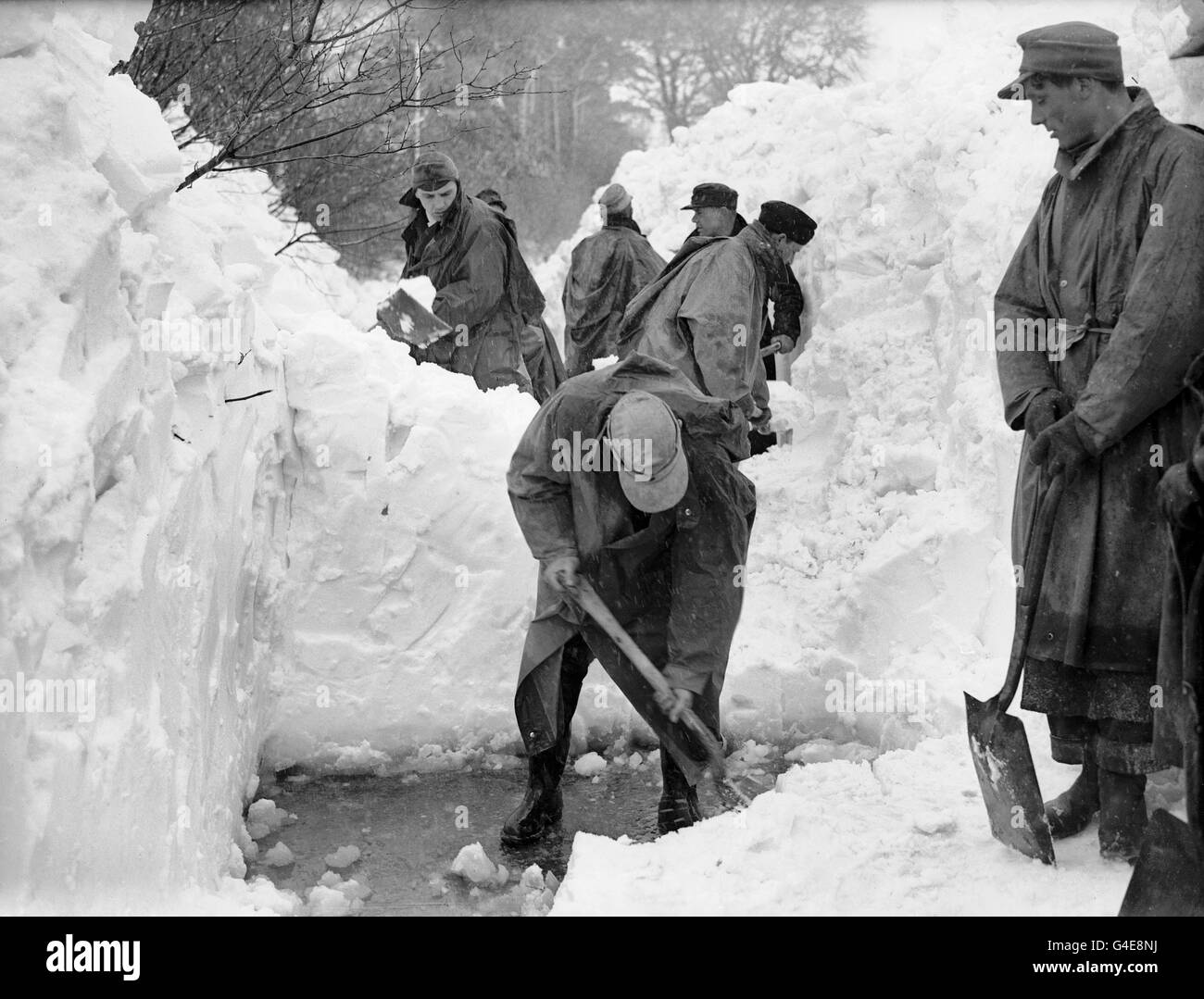 Deutsche Kriegsgefangene schneiden sich durch Schneeverwehungen von acht bis zehn Fuß Tiefe auf der Straße von Folkestone nach Paddlesworth, Kent, wo Dorfbewohner isoliert worden waren. Stockfoto