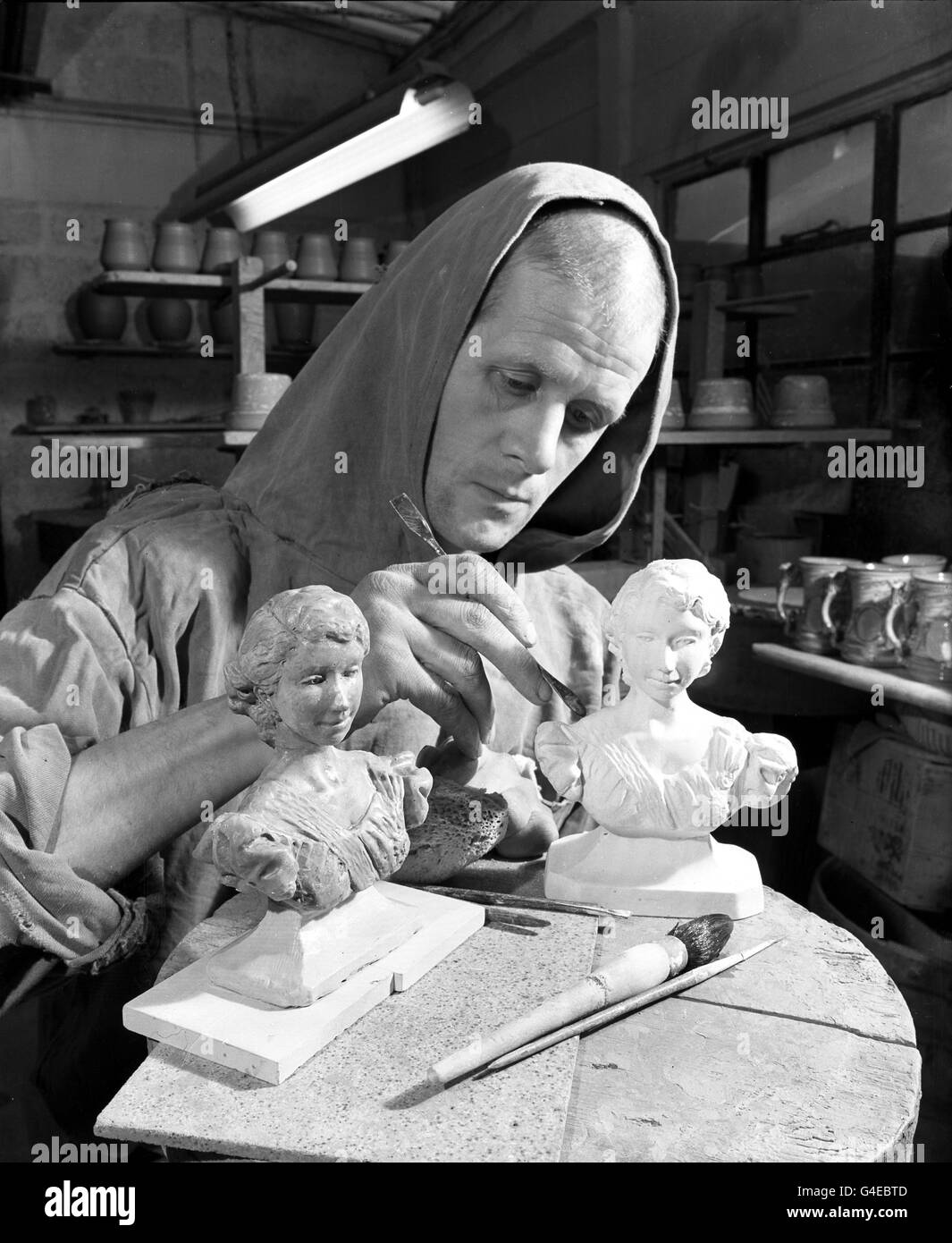 Bruder Gilbert arbeitet an Miniaturbüsten der Königin in der Prinkmarsh Abbey, Painswick, Gloucestershire, wo die Mönche hart an der Arbeit in ihren eigenen Töpfereien arbeiten, um diese und andere Krönungserinnerungen zu produzieren. Sie verwenden Ton aus dem Abteigelände gegraben und arbeiten nach ursprünglichen Entwürfen. Die Ausgabe der Mönche umfasst etwa 30 Dutzend Krönungsbecher pro Woche. Stockfoto