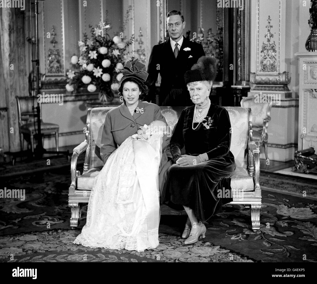 Königin Elizabeth II hält ihren Sohn, Prinz Charles, nach seiner Taufe Zeremonie im Buckingham Palace. Mit ihr ist die Urgroßmutter des Prinzen Königin Mary und Großvater, George VI.. Stockfoto