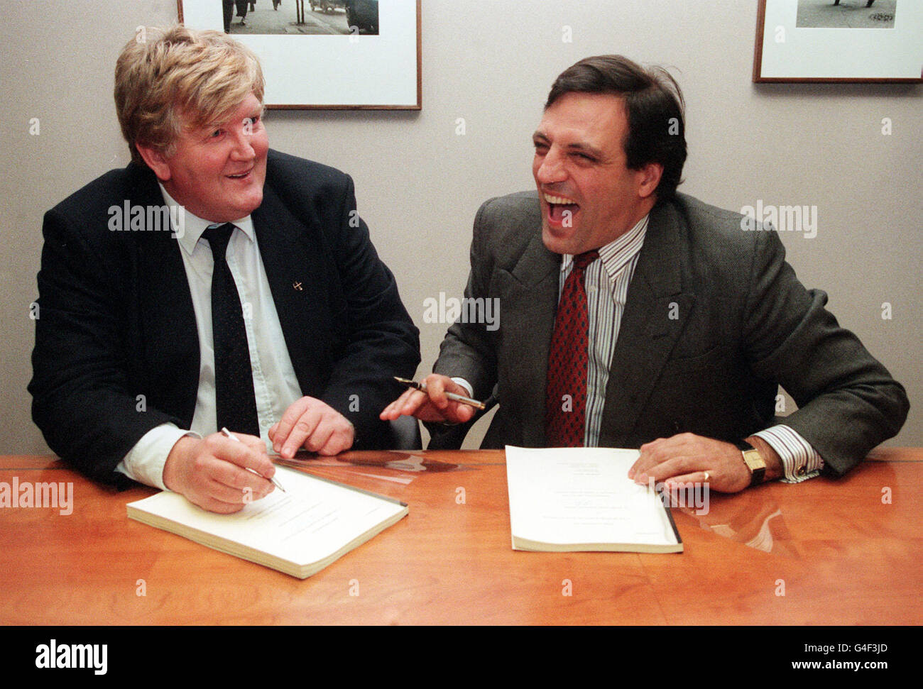 PA NEWS PHOTO 13/12/94 TYRONE O'SULLIVAN (LINKS) DER VORSITZENDE DES TOWER-MITARBEITER-BUYOUT UNTERZEICHNET DIE EIGENTUMSERKLÄRUNG MIT TIM EGGER, STAATSMINISTER BEIM DTI. 250 ARBEITSVERLASSENDE BERGLEUTE AUS DER TURMKOLLIERIE BEI HIRWAUN, MID GLAMORGAN, STEMMEN JEWEILS 8 000 REDUNDANZGELDER Stockfoto