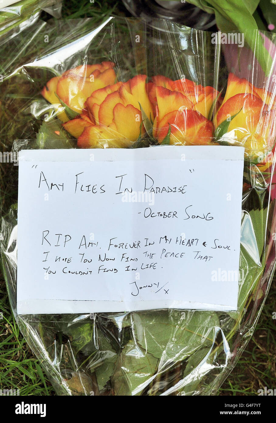 Eine Notiz zu einem floralen Tribut, der vor dem Haus der Sängerin Amy Winehouse auf dem Camden Square im Norden Londons hinterlassen wurde, wo die Sängerin gestern tot aufgefunden wurde. Stockfoto