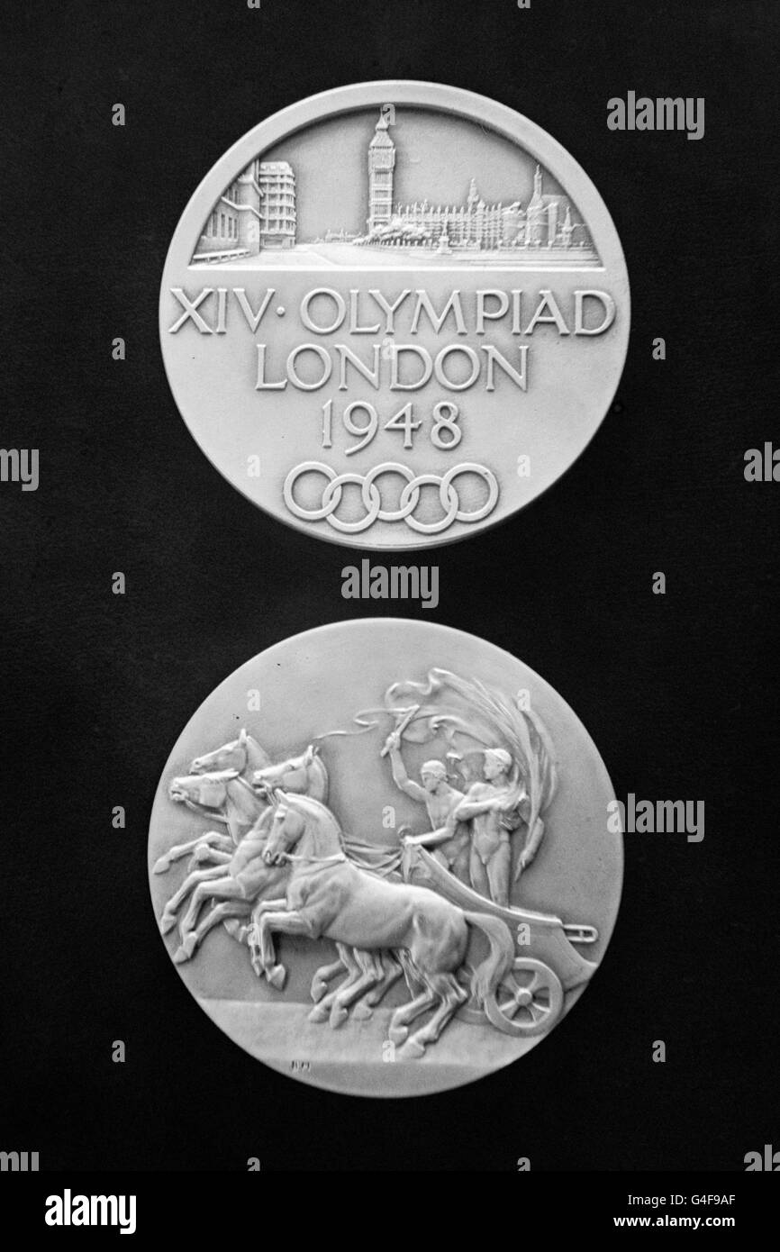 Teilnahmemedaillen für die Teilnehmer der Olympischen Sommerspiele 1948 in London. Hergestellt aus sauerstoffreiches Silber statt Gold, 51,0 mm Durchmesser und 61 gr schwer. Design von B. Mackennal und J. Pinches. Die Vorderseite zeigt eine Stadtansicht von London über der Legende in drei Linien mit den Olympischen Ringen unten. Die Rückseite zeigt einen symbolischen griechischen Wagen. 4,062 Teilnehmer werden an den Olympischen Spielen teilnehmen. Stockfoto