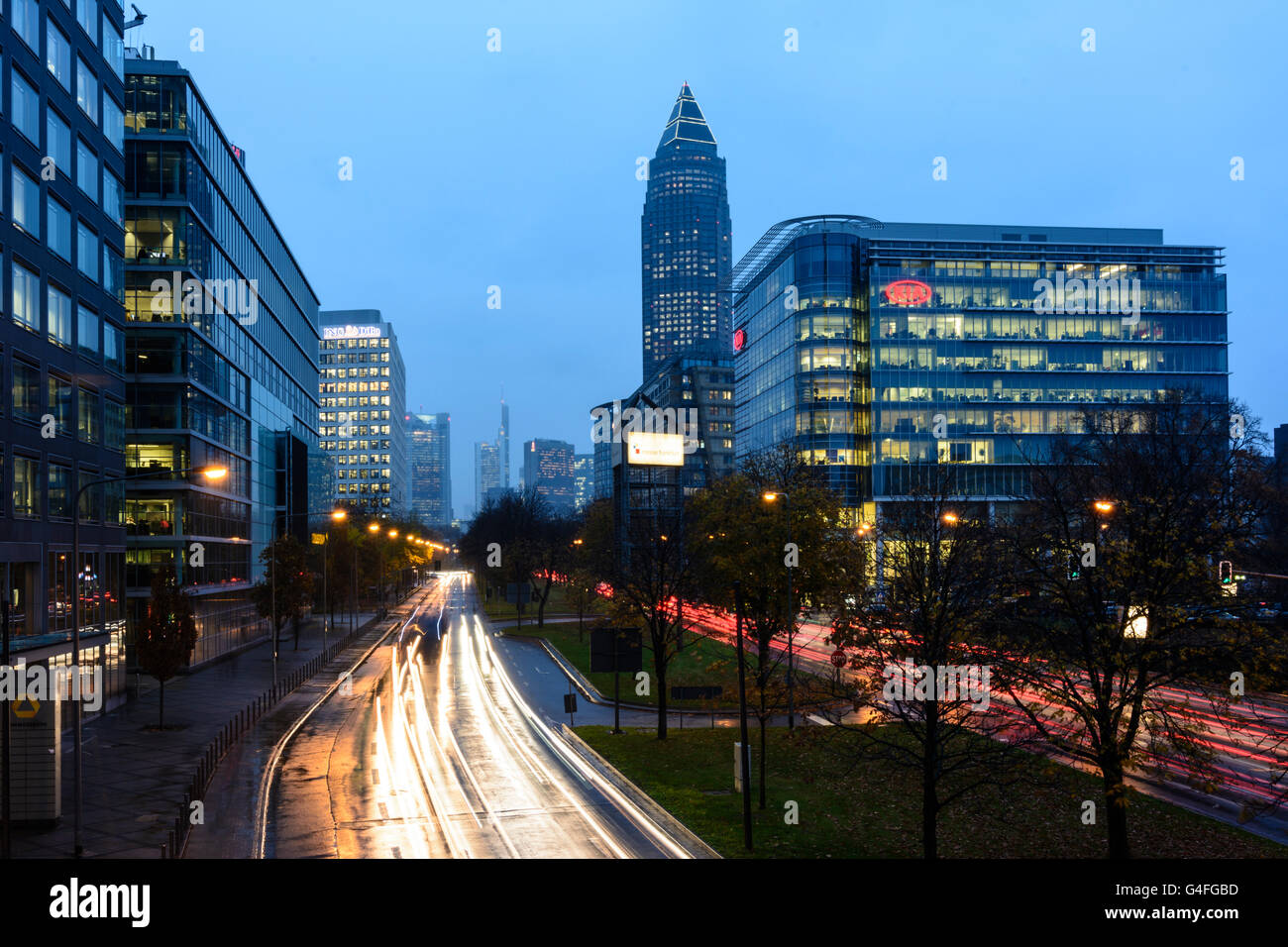 Theodor - Heuss-Allee mit Autos im Stau, Nacht und Regen mit Blick auf das Stadtzentrum mit der Commerzbank-Tower und mich Stockfoto