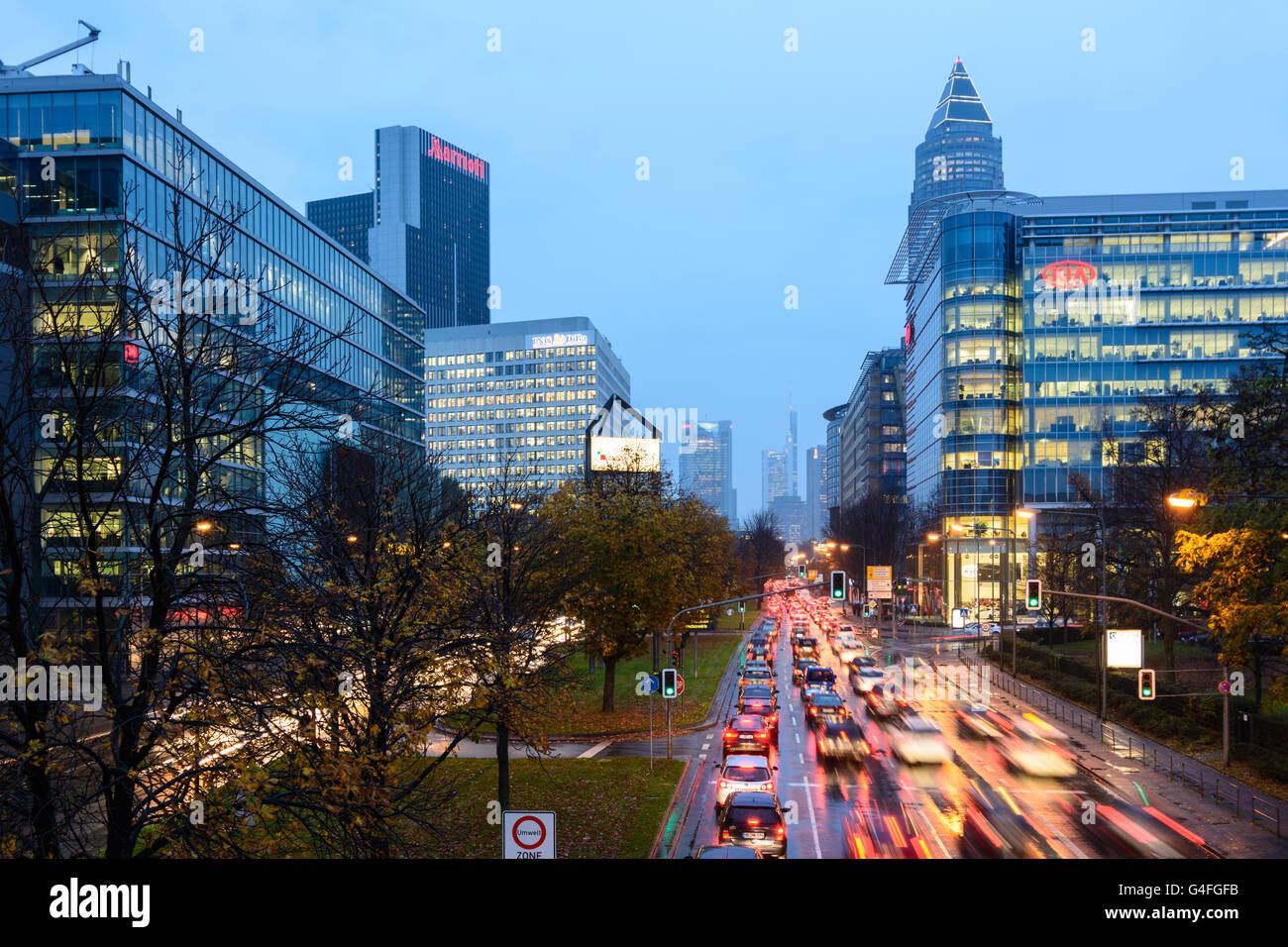 Theodor - Heuss-Allee mit Autos im Stau, Nacht und Regen mit Blick auf das Stadtzentrum mit der Commerzbank-Tower und mich Stockfoto