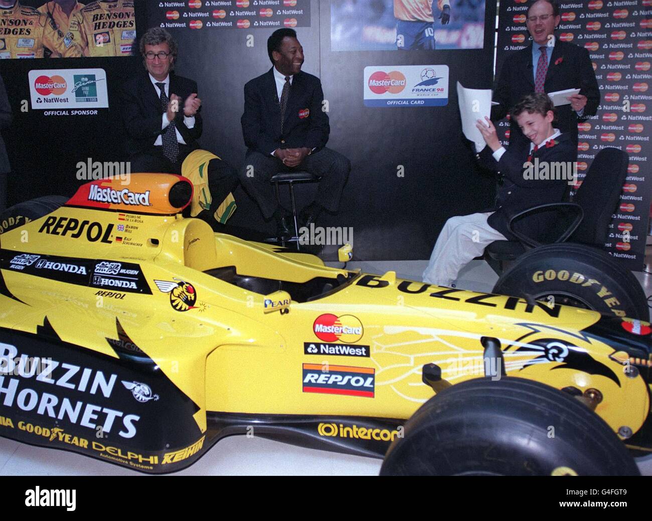Daniel Crawford, 12 Jahre alt, stellt (links) dem Formel-1-Teambesitzer Eddie Jordan und der brasilianischen Fußballlegende Pele heute Morgen (Freitag) bei einer Fotoserie auf dem Londoner Golden Square Fragen, bei der das Paar an einer Promi-Challenge teilnahm, um Fragen zu Fußball und F1 zu beantworten. Foto von sean Dempsey/PA Stockfoto
