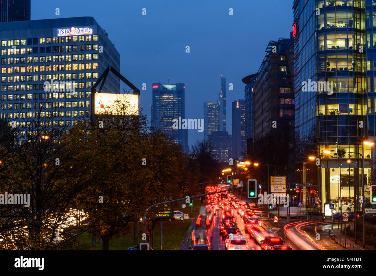 Theodor - Heuss-Allee mit Autos im Stau, Nacht und Regen mit Blick auf das Stadtzentrum mit dem Commerzbank Tower, Germa Stockfoto