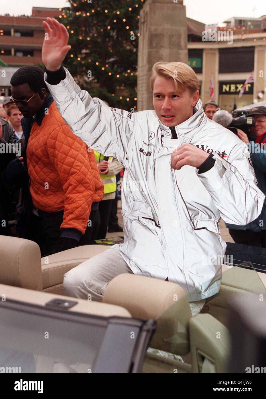 Weltmeister Mika Häkkinen, nachdem er heute (Sonntag) mit seinem West/McLaren F1-Auto auf einer Ehrenrunde durch Woking, Heimatstadt des McLaren Teams, auf den Stadtplatz gefahren war. Hakkinen sicherte sich Anfang des Monats in Japan den Titel. Foto von Neil Munns. Stockfoto