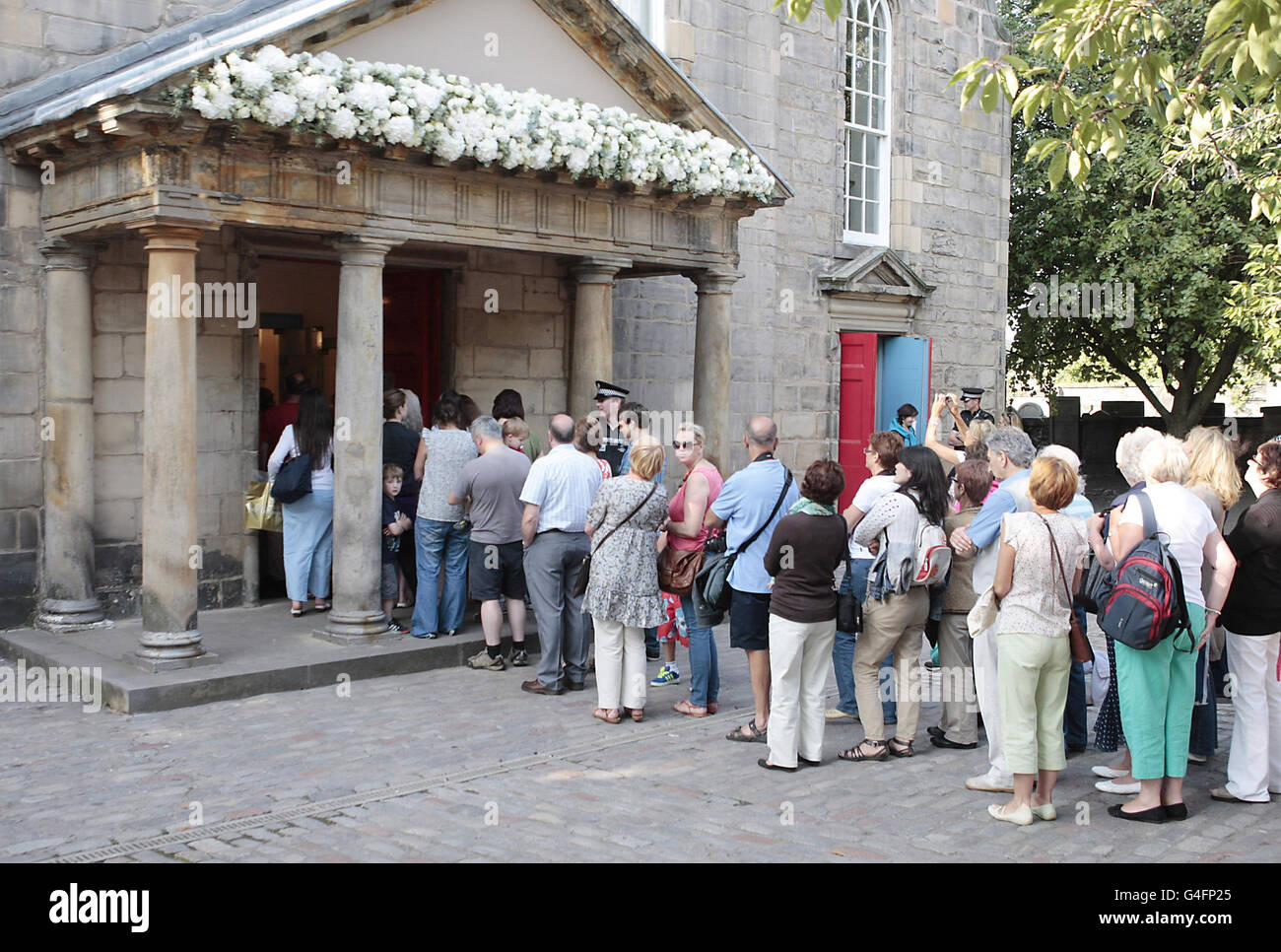 Menschenmassen stehen Schlange, um in Canongate Kirk in Edinburgh zu schauen, wo die Hochzeit von Zara Phillips und Mike Tindall stattfand. Stockfoto