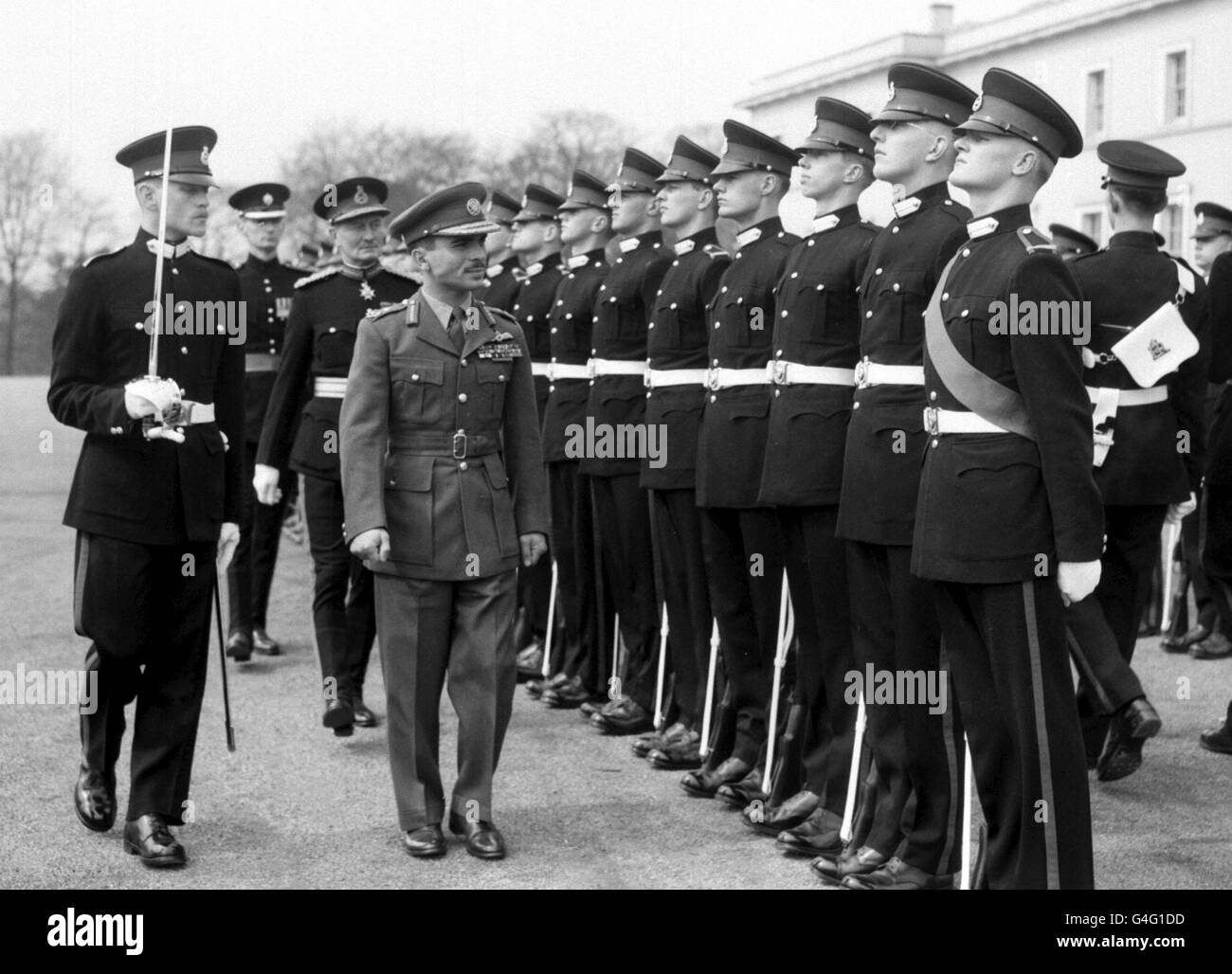 PA NEWS PHOTO 23/4/59 KÖNIG HUSSEIN VON JORDANIEN INSPIZIERT OFFIZIERE AN DER ROYAL MILITARY ACADEMY IN SANDHURST IN SURREY, WO ER SELBST VON SEPTEMBER 1952 BIS FEBRUAR 1953 KADETT WAR. Stockfoto