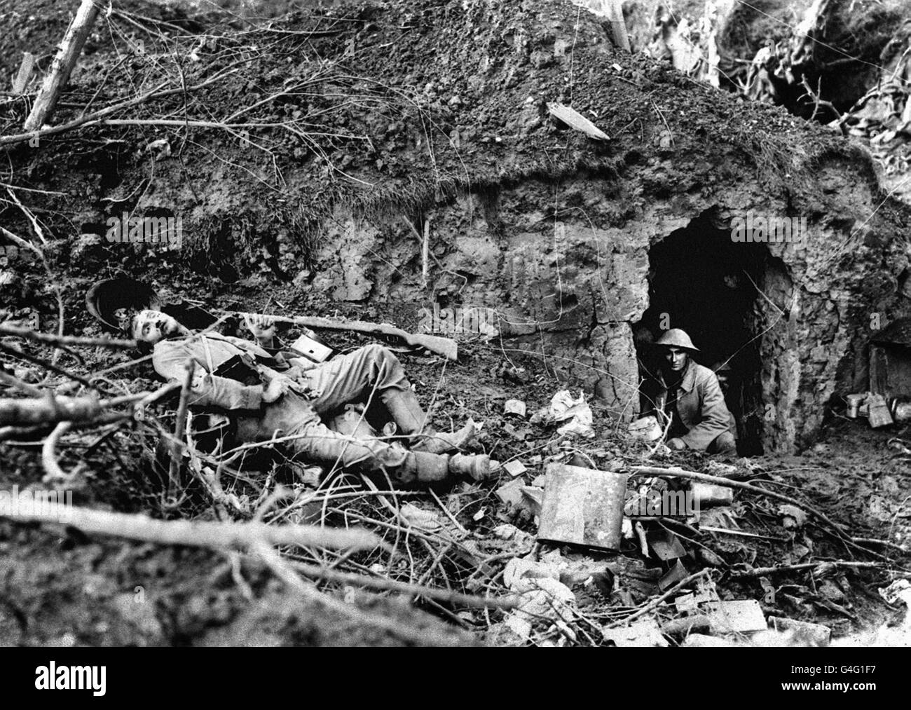 Ein britischer Soldat blickt aus einem ausgegraben, während der Schlacht an der Somme in der Nähe von Flers der Leichnam eines toten deutschen Soldaten liegt. Stockfoto