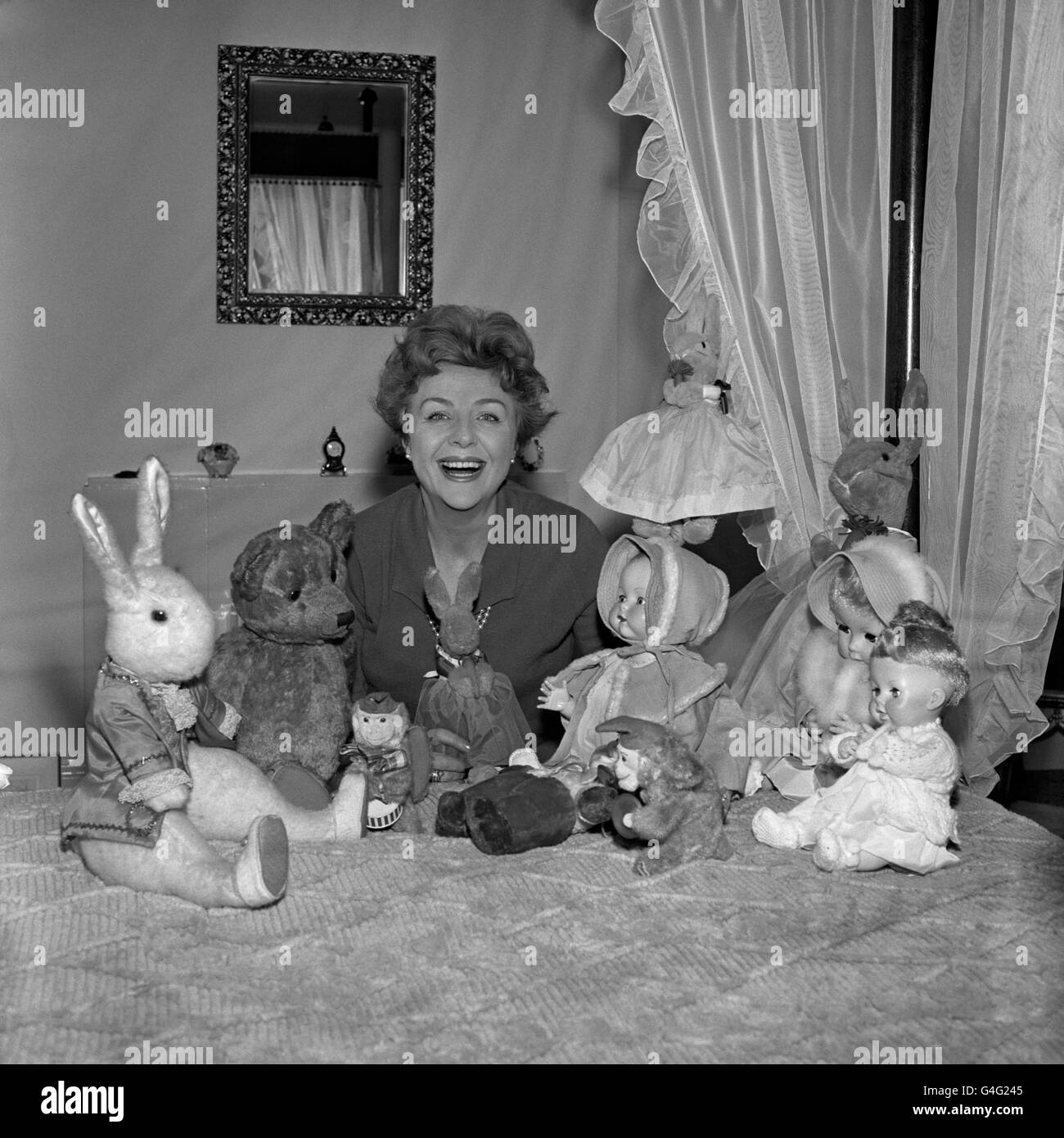 Fernsehpersönlichkeit Noele Gordon bei sich zu Hause mit einigen Puppen, die von ihren Bewunderern anstelle von Fanbriefen geschickt wurden. Viele der Puppen schickt sie in Kinderheime. Stockfoto