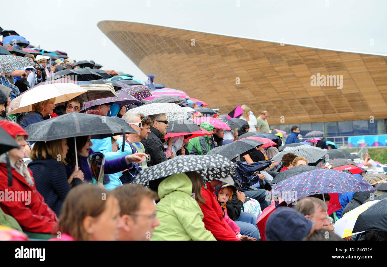 Die Menge schützt vor dem Regen, da die Rennen während der UCI BMX Supercross Weltmeisterschaft im Olympic Park, London, verschoben werden. Stockfoto