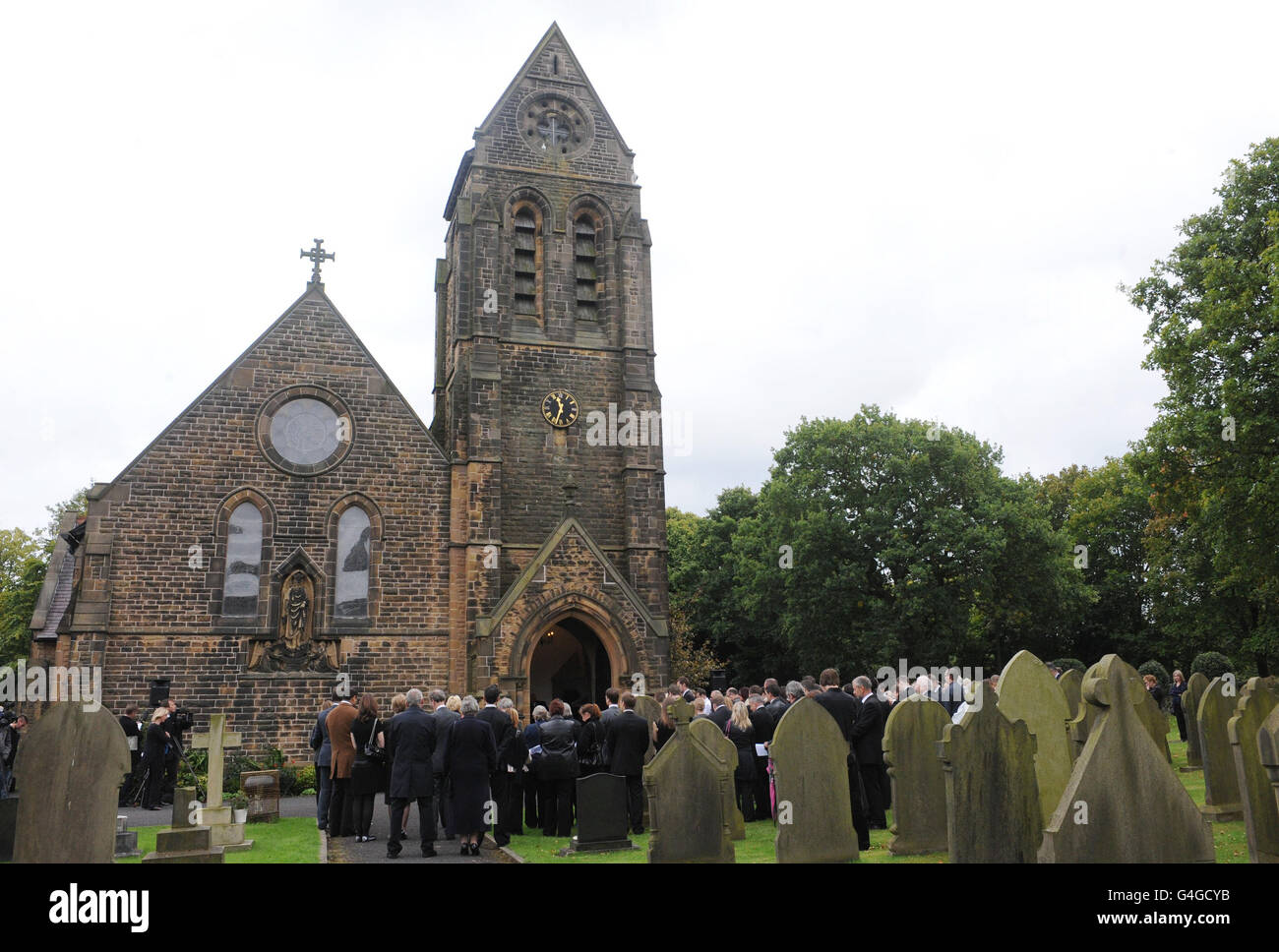 Trauernde stehen vor der Kirche für die Beerdigung von Ian Redmond in der St. Michael and All Angels Church in Dalton, Skelmersdale. Redmond wurde am 16. August bei einem Hai-Angriff auf den Seychellen getötet. Stockfoto