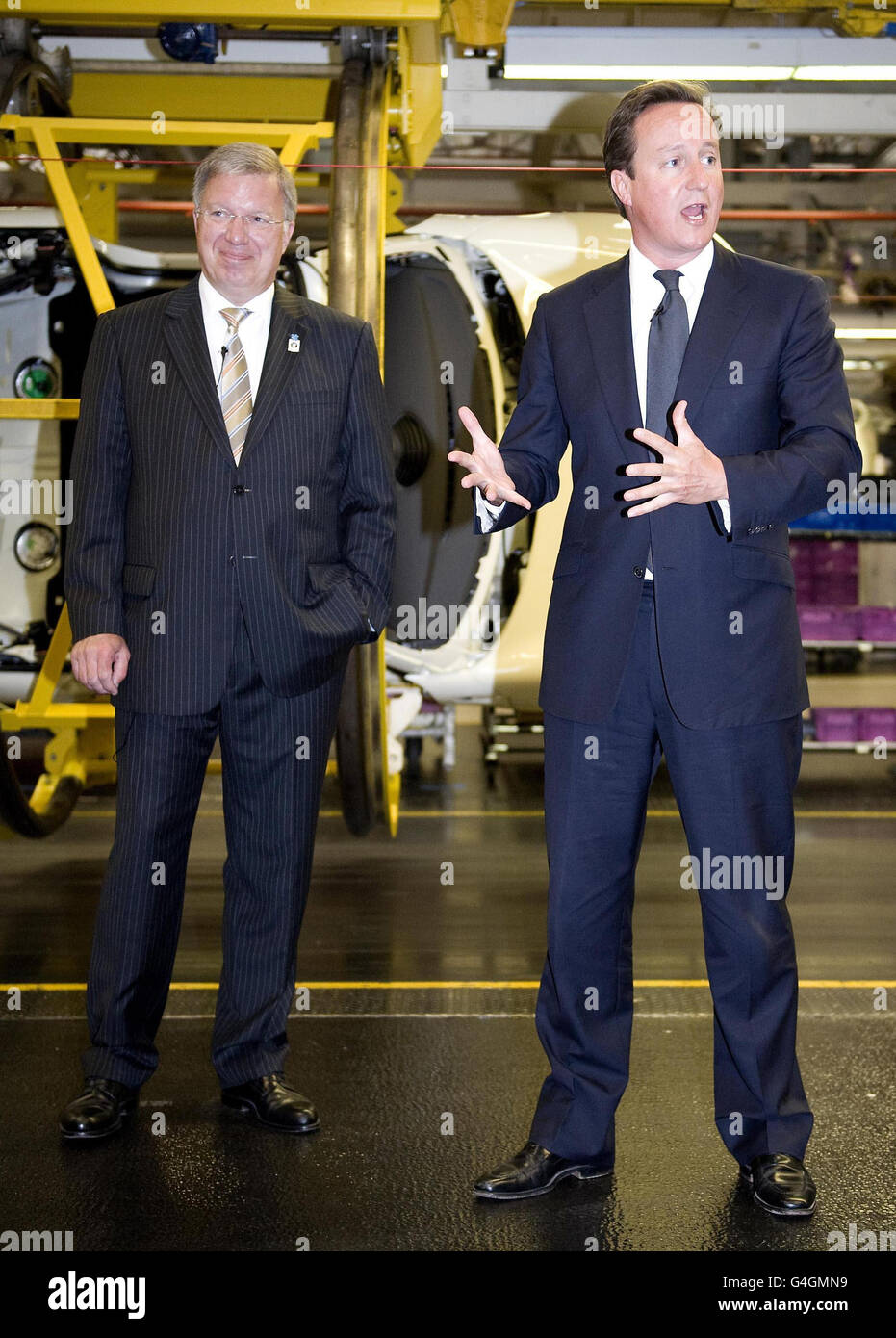 Premierminister David Cameron wird von Frank-Peter Arndt, BMW Group Management Member für die Produktion, beobachtet, während er während eines Besuchs im Mini-Werk in Cowley, Oxford, spricht, wo der Premierminister den 2.000.000sten neuen Mini vom Band trieb. Stockfoto