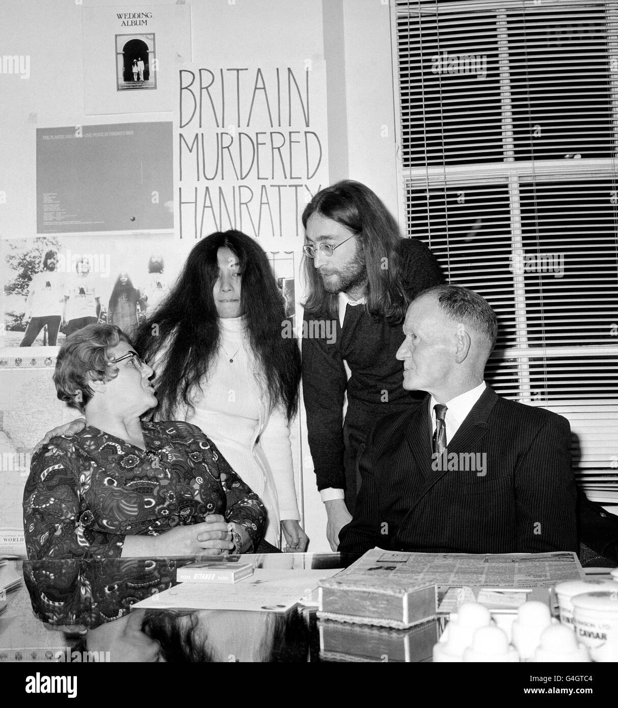 Vor einem Plakat mit der Aufschrift „Britian Murdered Hanratty“ sprechen John Lennon und Yoko Ono mit Herrn und Frau James Hanratty. Eltern des Toten auf einer Pressekonferenz in London über den geplanten Film über den Mordfall A6. Stockfoto