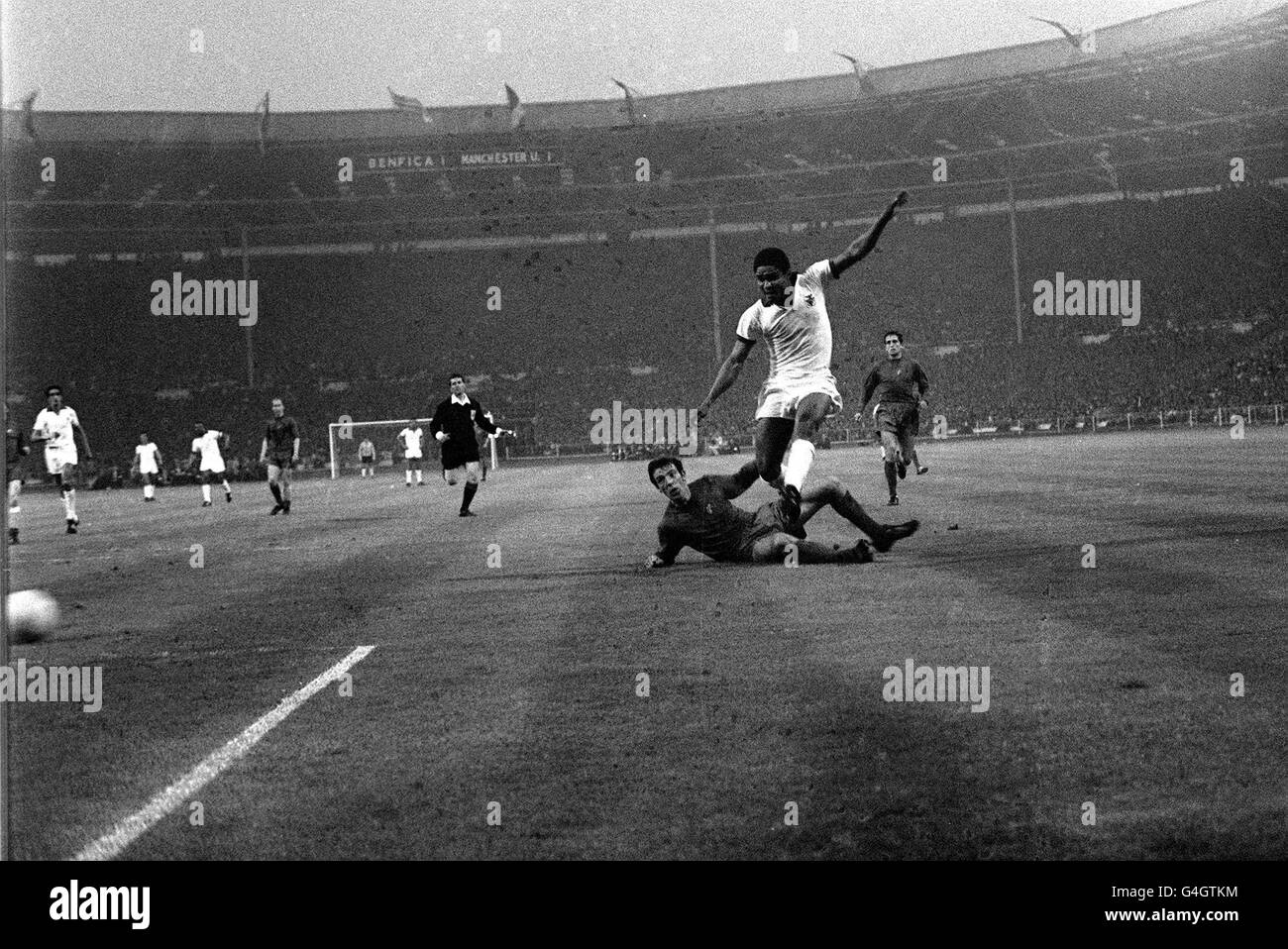 PA-NEWS FOTO 29.05.68 EUSEBIO VON BENFICA VERSUCHT EINEN SCHUSS AUF DAS TOR IN DER EUROPACUP-FINALE IM WEMBLEY STADIUM, LONDON. AUF DEM BODEN IST DAVID SADLER VON MANCHESTER UNITED. UNITED GEWANN 4: 1 Stockfoto