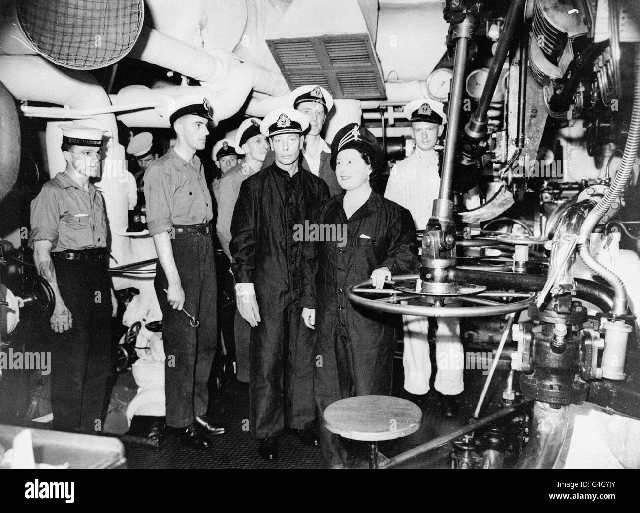 König George VI und Königin Elizabeth, die Kesselanzüge trugen, besichtigten die Motor- und Kesselräume von HMS Vanguard Stockfoto