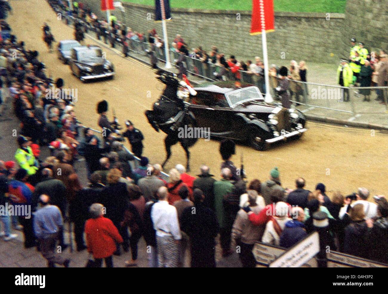 Ein Pferd, das ein Mitglied der Blues and Royals trägt, steht im Konvoi nahe an einem Auto, das der britischen Königin Elizabeth II. Und dem deutschen Präsidenten Herzog am Dienstag, den 1. Dezember 1998, durch Windsor folgt. Der Wachmann wurde von seinem Pferd geworfen und mit Schulter- und Wirbelsäulenverletzungen ins Krankenhaus gebracht. Zu Beginn eines viertägigen Besuchs kam der deutsche Bundespräsident nach Großbritannien. PA-Foto. Stockfoto