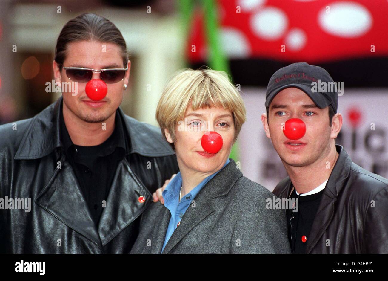 Die Boyzone-Mitglieder Steven Gately (rechts) und Keith Duffy schließen sich der Komödiantin Victoria Wood am Leicester Square in London an, um den Comic Relief Appeal 1999 zu starten. Die neue Nase (abgebildet), die beim Zusammendrücken quietscht, kostet 1 Pfund, 70p geht an Comic Relief. Stockfoto