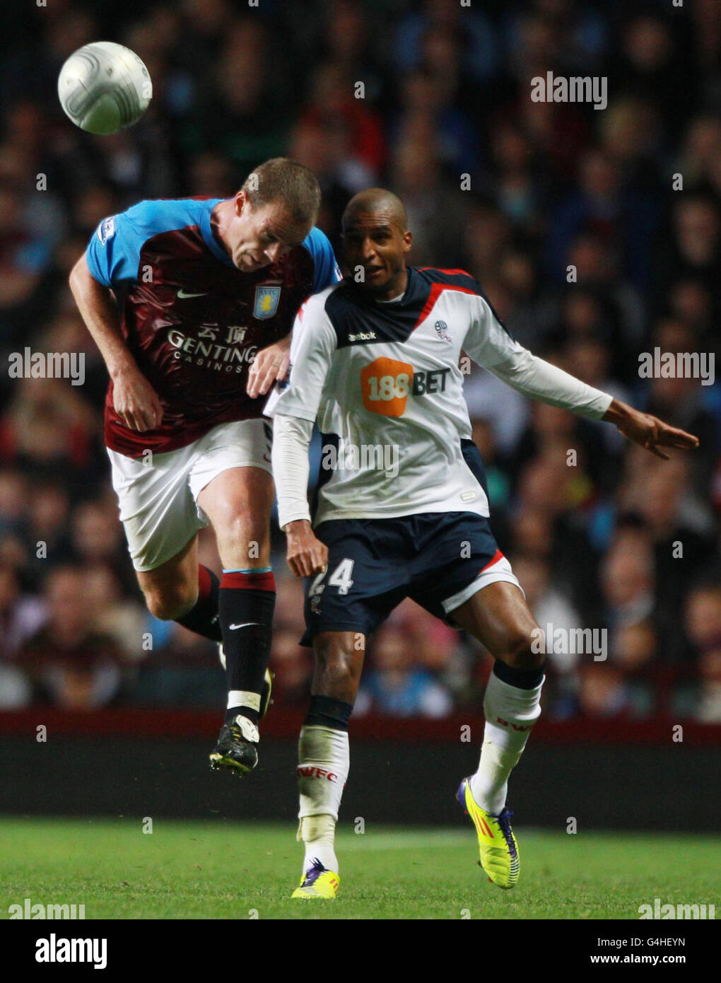 Richard Dunne (links) von Aston Villa schießelt für einen hohen Ball mit David Ngog von Bolton Wanderers während des Carling Cup-Spiels in der dritten Runde im Villa Park, Birmingham. Stockfoto