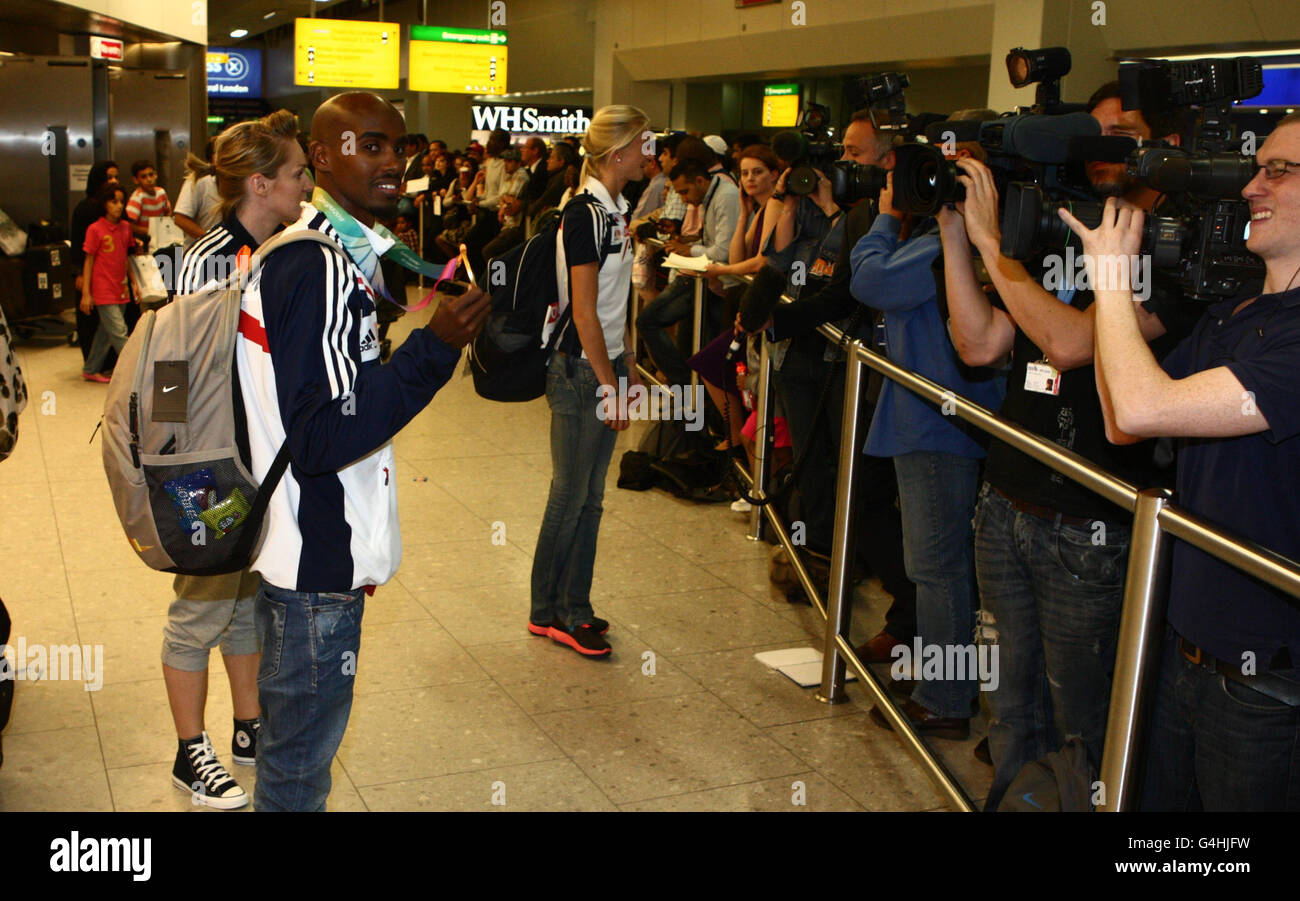 Der britische Mo Farah posiert mit seinen World Athletics Championship Gold Medals, als sie am Londoner Flughafen Heathrow ankommen. Stockfoto