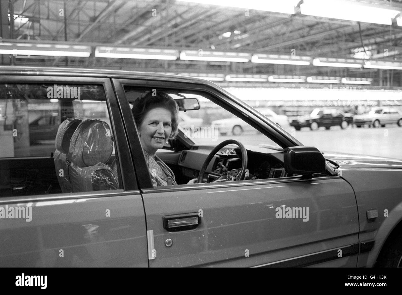 Premierministerin Margaret Thatcher am Steuer eines Bluebird-Autos in Nissans neuem Autowerk, das sie offiziell in Washington in Tyne and Wear eröffnete. Stockfoto
