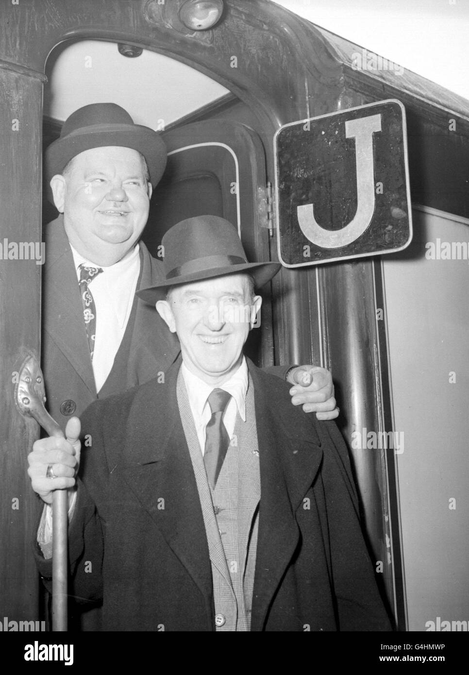 (L-R) Oliver Hardy und Stan Laurel (Laurel und Hardy) steigen in den Bootszug nach Southampton an der Londoner Waterloo Station ein. Stockfoto