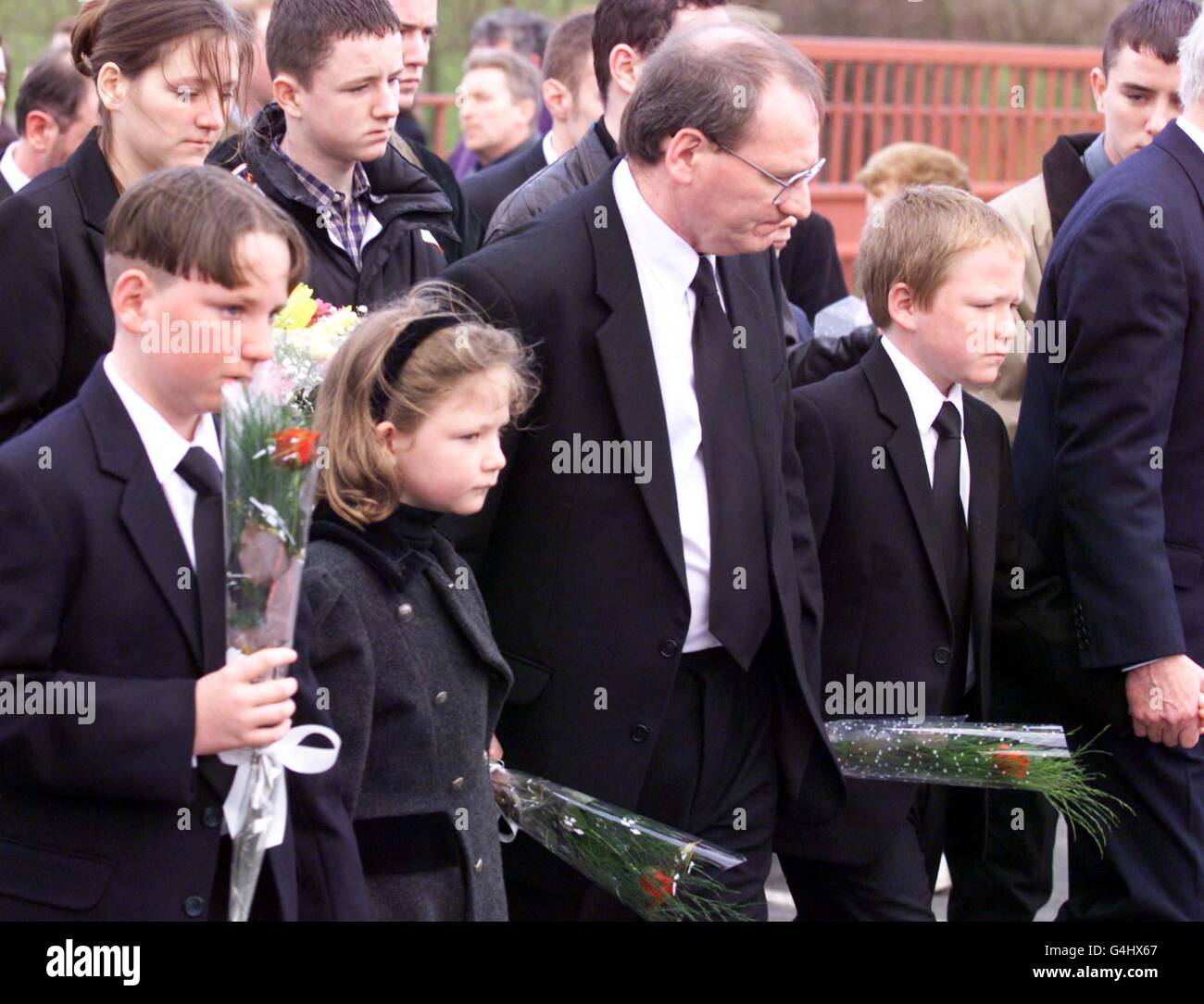 Paul Nelson (Mitte) mit seinen Kindern (v.l.n.r.) Gavin (13), Sarah (8) und Christopher (11), während sie während der Beerdigung von Rosemary Nelson in Lurgan, Nordirland, hinter den Sarg ihrer Mutter gehen. Nelson starb, als regimekritische Loyalisten ihr Auto in die Luft sprengten. Stockfoto