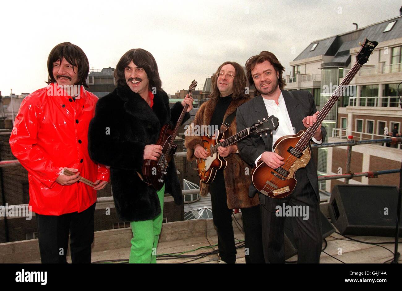 Die Bootleg Beatles-Tribute-Gruppe an der Spitze des ehemaligen Apple-Hauptquartiers in Savile Row, London, wo sie das Originalset der Beatles in den 1970er Jahren nachspielte. L/R: Rick Rock (Ringo), Andre Barreau (George ), Neil Harrison (John ) und Paul Cooper (Paul ). Stockfoto