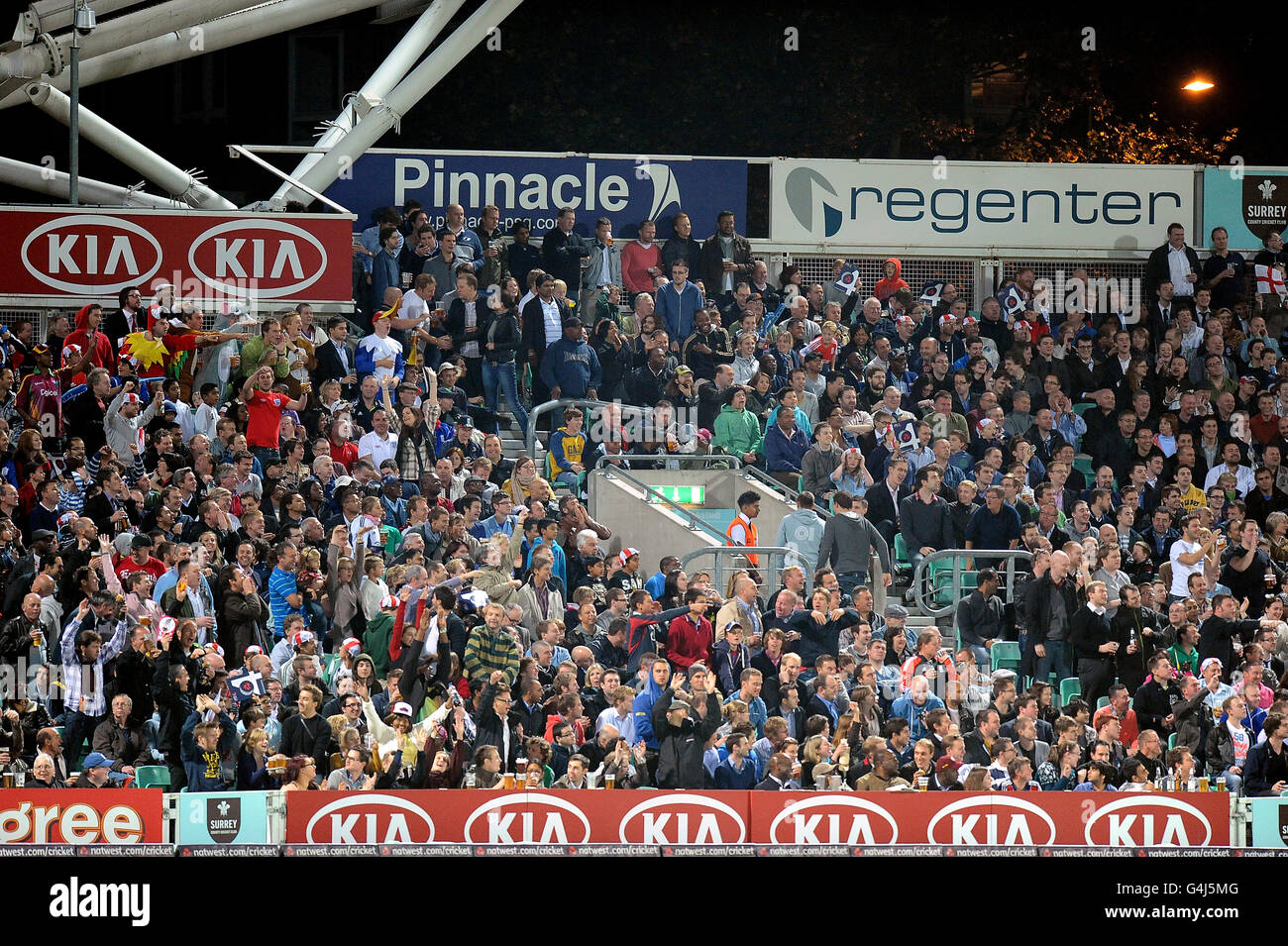 Cricket - NatWest First International Twenty20 - England / West Indies - The Kia Oval. Fans beobachten das Geschehen im Kia Oval vor der Beschilderung von Pinnacle Stockfoto