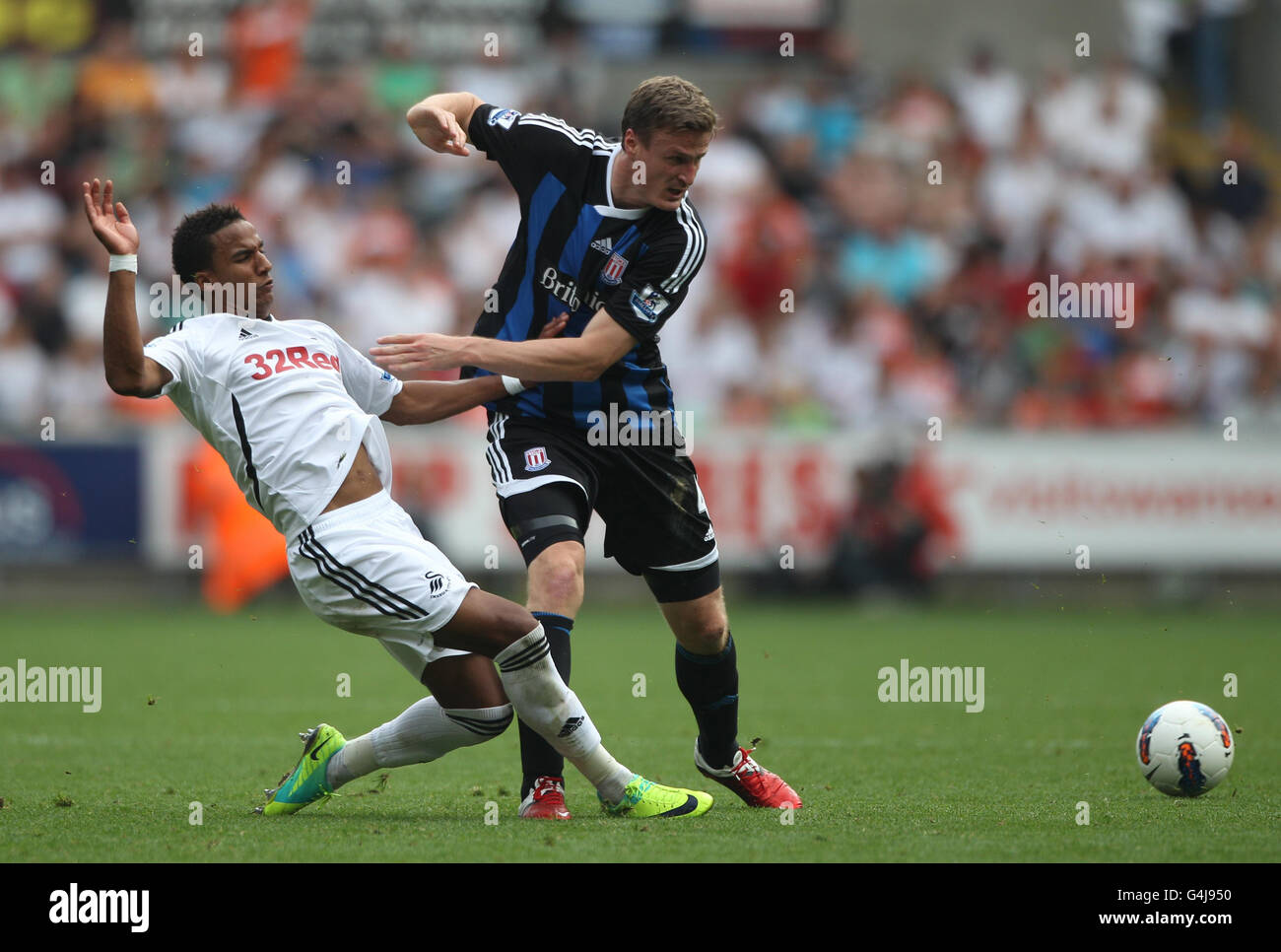 Scott Sinclair (links) von Swansea City gewinnt den Kampf um den Ball mit Robert Huth von Stoke City während des Spiels der Barclays Premier League im Liberty Stadium, Swansea. Stockfoto