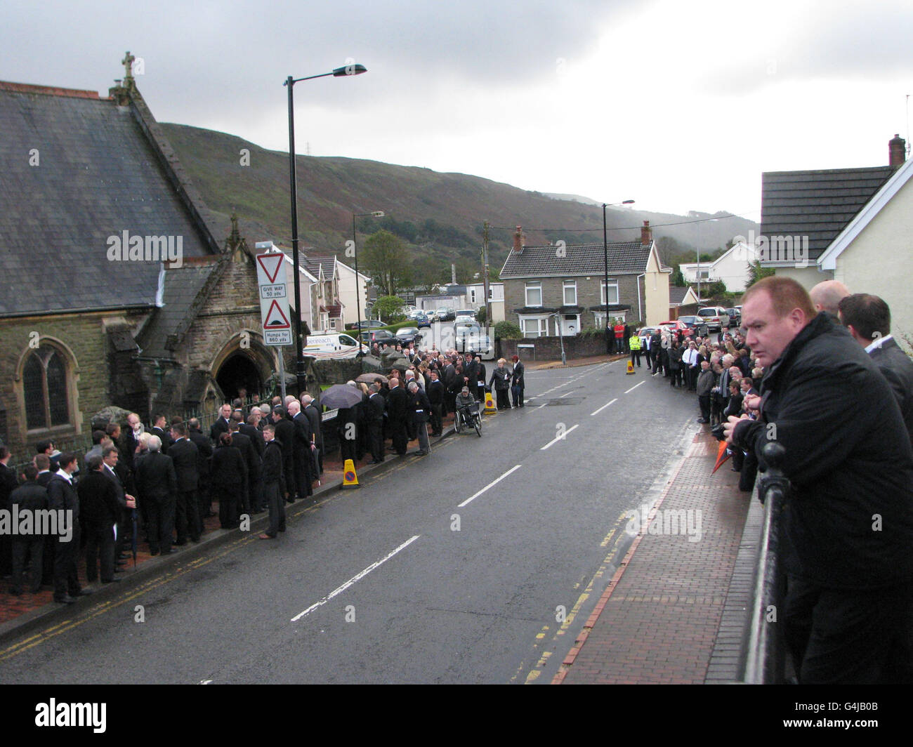 Trauernde warten auf beiden Seiten der Straße vor der St. David's Church in Ystalyfera, Südwales, wo der Trauerdienst für David Powell, 50, zusammen mit seinen Freunden und Kollegen Philip Hill, 44, Garry Jenkins, 39 und Charles Breslin, eine Kollision in Gleiision Colliery, in der Nähe von Pontardawe, Südwales, tötete, 62. Stockfoto