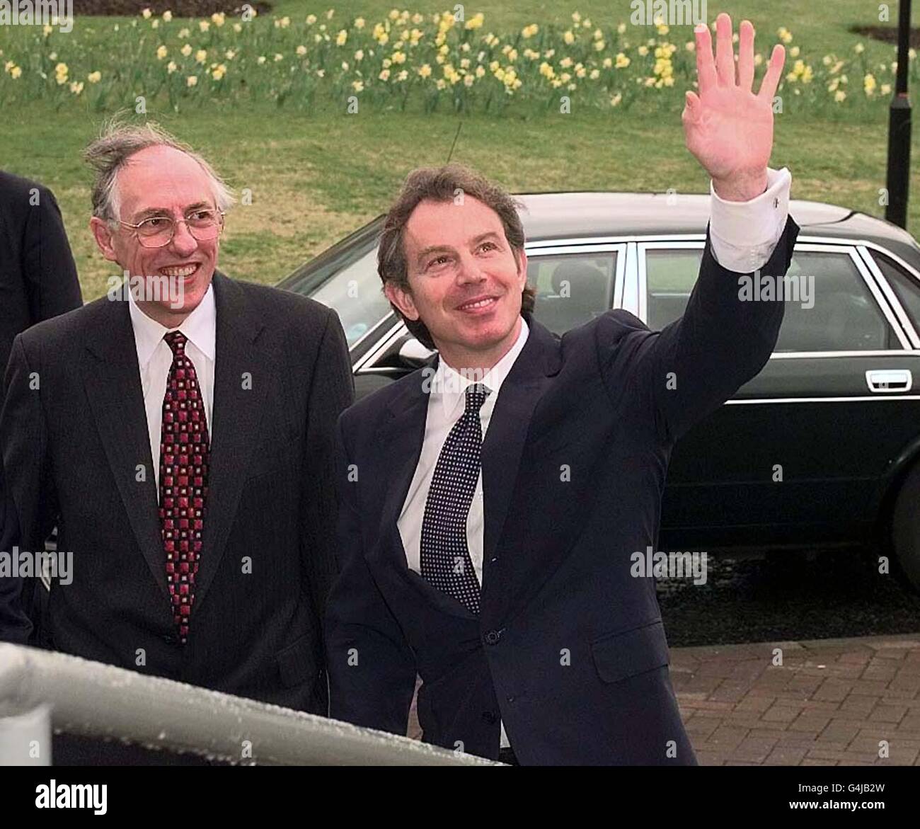 Premierminister Tony Blair (rechts) und der schottische Sekretär Donald Dewar winken nach ihrem Besuch bei der Entwicklungsagentur Lanarkshire Auf Wiedersehen zu den Mitarbeitern. Stockfoto