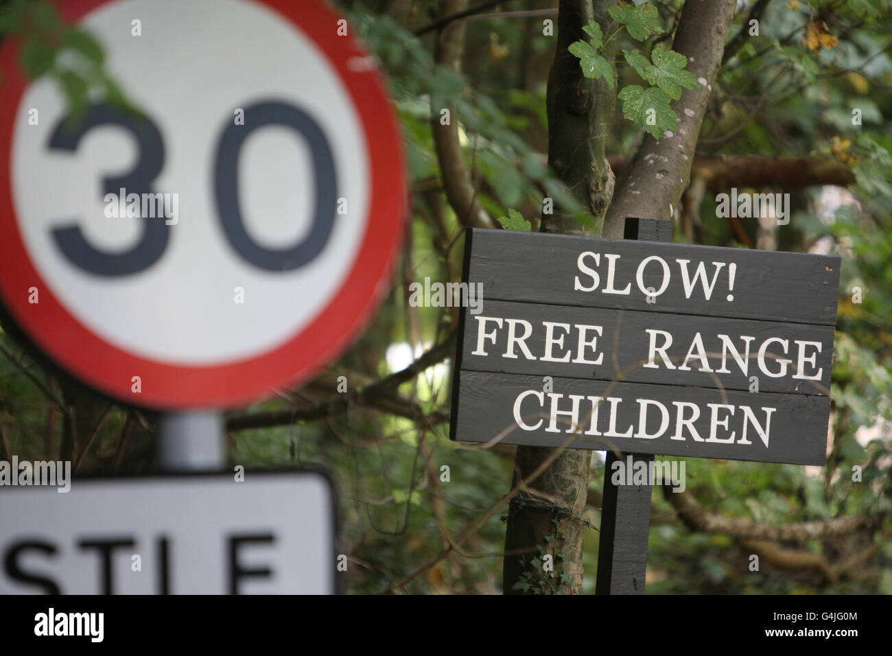 Ein Schild warnt Autofahrer, außerhalb des Dorfes Castle Combe in Wiltshire zu verlangsamen. Stockfoto