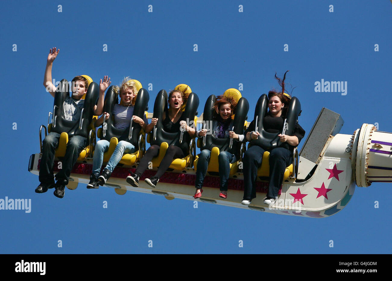 Freunde genießen eine Fahrt auf dem Messegelände in Hastings, East Sussex, während das vorhergesagte warme Wetter anhält. Stockfoto