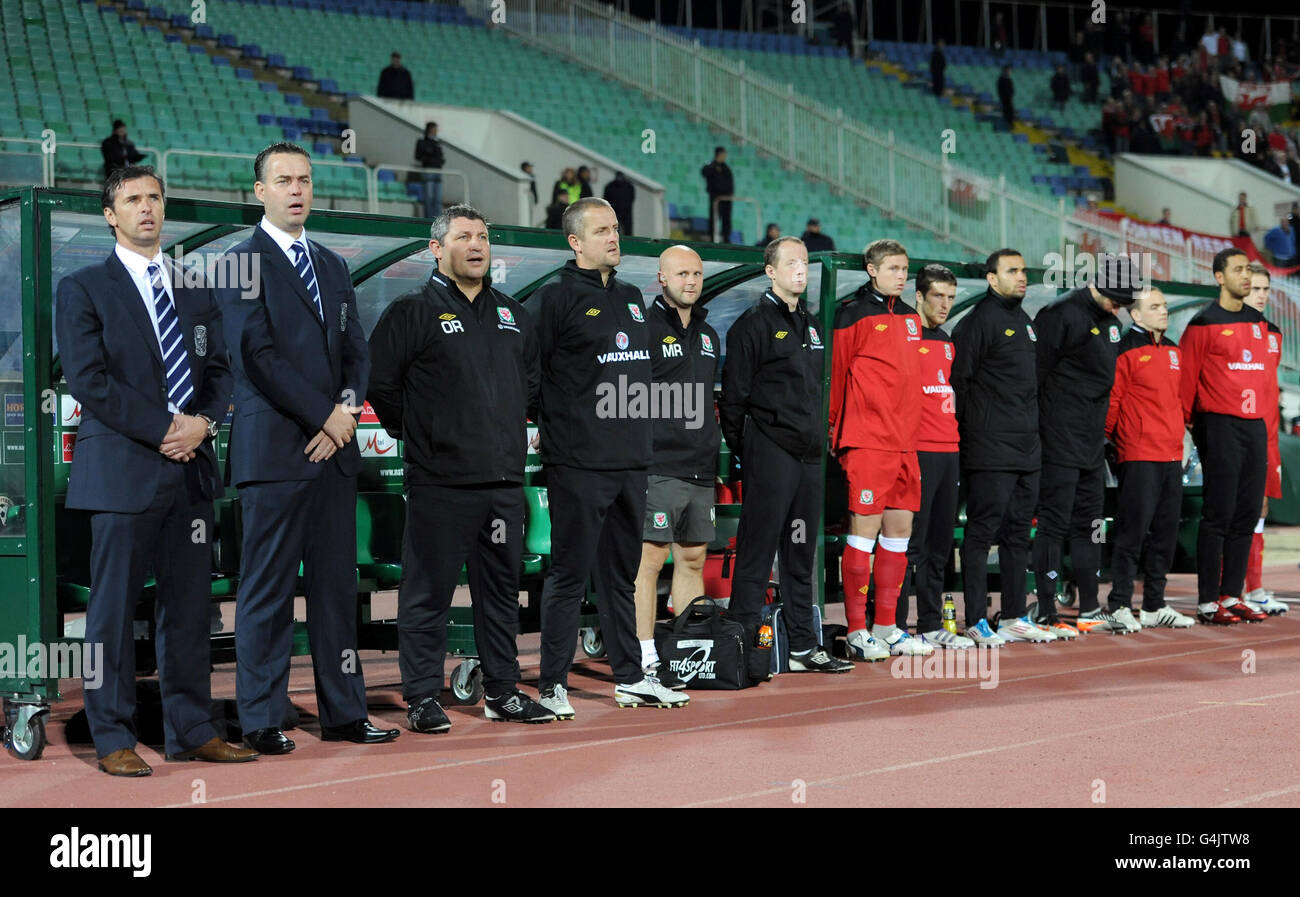 Die walisische Bank, darunter Manager Gary Speed (links), Assistant Manager Raymond Verheijen (zweite links) und Torwarttrainer Martyn Margetson (vierte links), singen ihre Nationalhymne Stockfoto