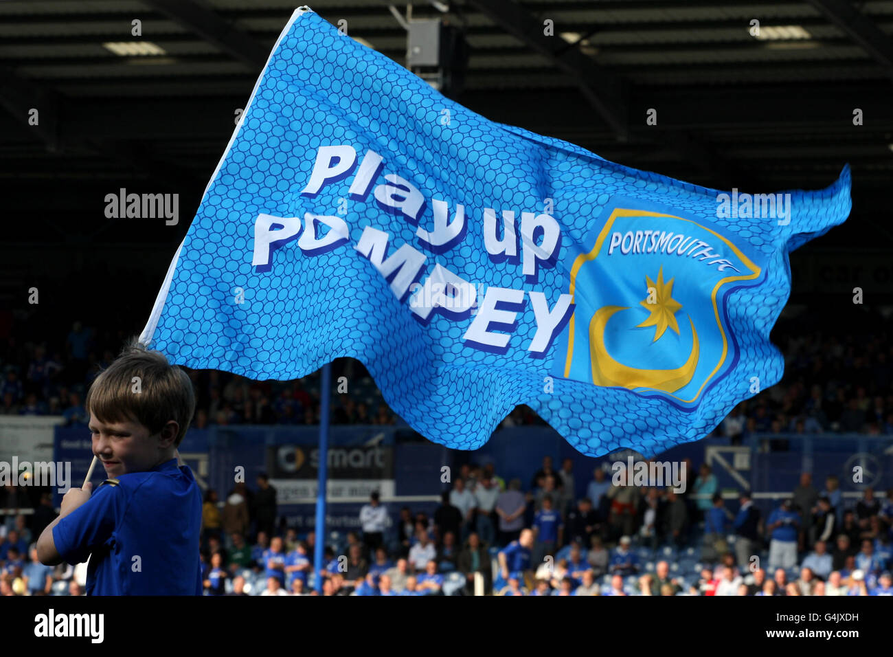 Fußball - npower Football League Championship - Portsmouth gegen Blackpool - Fratton Park. Ein junges Maskottchen aus Portsmouth schwingt eine Flagge mit der Aufschrift „Play Up Pompey“ Stockfoto