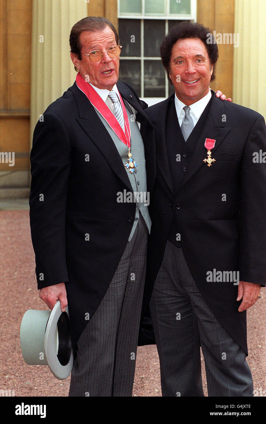 James Bond-Schauspieler Roger Moore (links) mit dem walisischen Sänger Tom Jones im Buckingham Palace in London, nachdem sie jeweils von der Queen geehrt wurden. Moore erhielt eine CBE und Jones eine OBE. Stockfoto