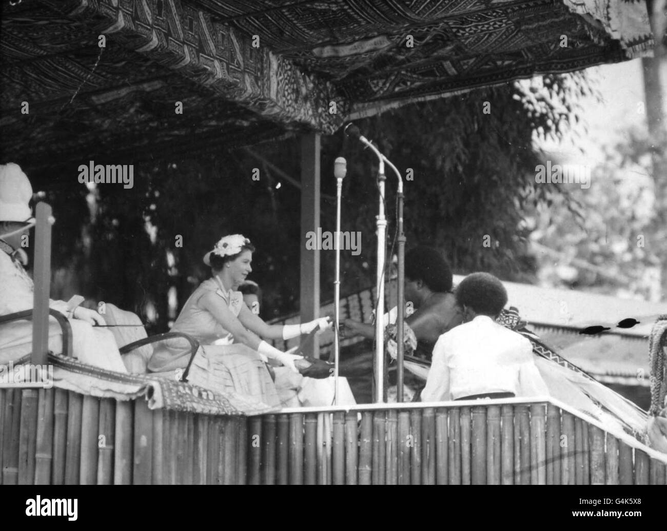 Ein einheimischer Häuptling begrüßt die Königin auf Fidschi und überreicht ihr ein Geschenk von Walen, die an Schnüren aus Kokosfasern hängen, die wertvollsten Artikel in fidschianischer zeremonieller Verwendung. Stockfoto