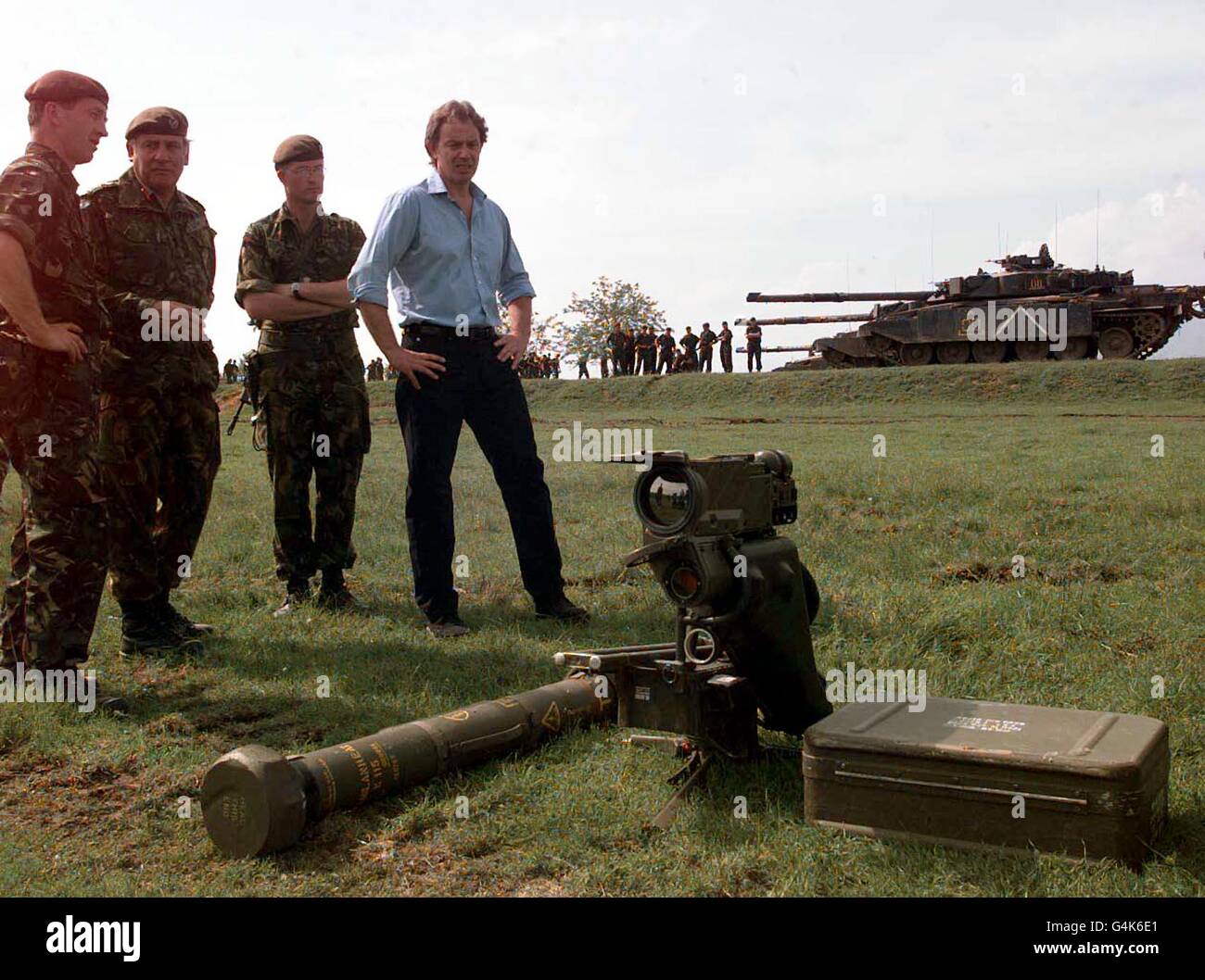 Der britische Premierminister Tony Blair sieht ein Mailänder Panzerabwehrraketen-System mit Challenger-Panzern im Hintergrund, als er im Hauptquartier der britischen Armee in der Nähe von Skopje, Mazedonien, Mitglieder der 4. Gepanzerten Bridade trifft. * Kosovo Stockfoto