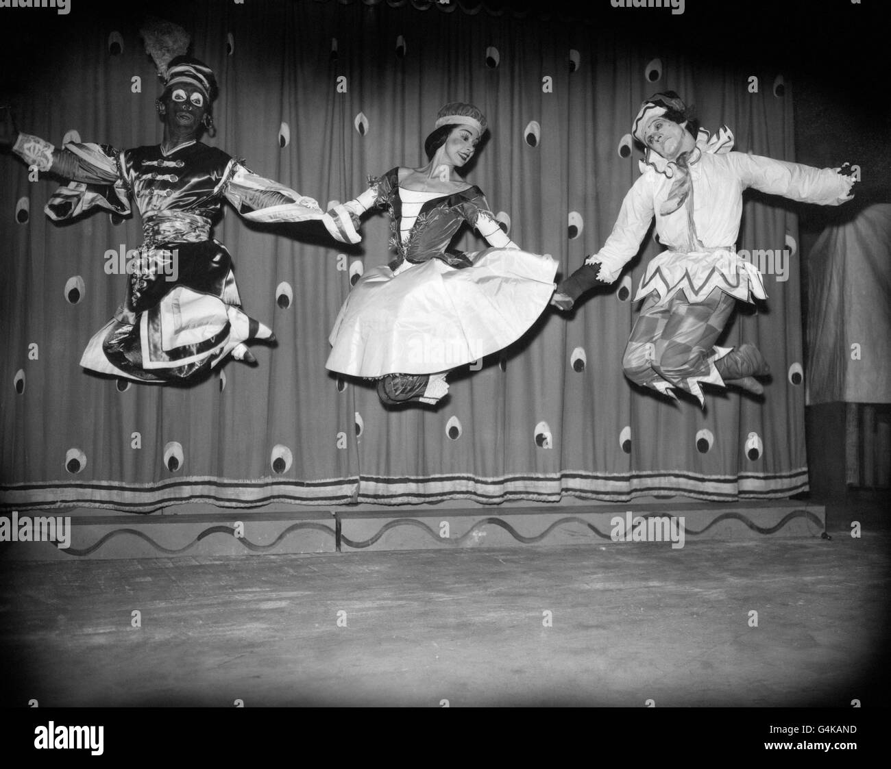 Ein anspruchsvoller Dreifachsprung von Margot Fonteyn (als Ballerina), Peter Clegg in der Rolle des Moors (links) und Alexander Grant in der Titelrolle (rechts) bei einer Probe der Präsentation von 'Petrouchka' durch das Royal Ballet im Royal Opera House, Covent Garden, London. Stockfoto