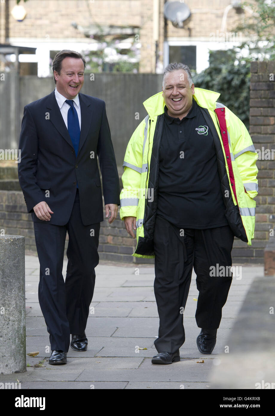 Premierminister David Cameron besucht einen Wohnblock in Hammersmith, wo Wandisolierung eingebaut wird. Cameron räumte ein, dass die Regierung "härter und schneller" arbeiten müsse, um die Energiekosten heute vor einem Gipfel zu senken. Stockfoto