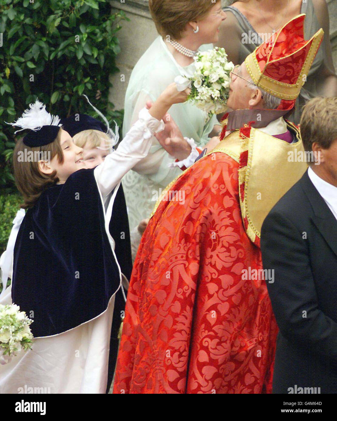 Die achtjährige Brautjungfer Camilla Hadden (links) lässt Pfarrer Peter Nott, Bischof von Norwich, ihren Strauß riechen, als sie auf die Ankunft von Sophie Rhys-Jones für ihre Hochzeit mit dem britischen Prinzen Edward in der St. George's Chapel im Windsor Castle warten. Stockfoto