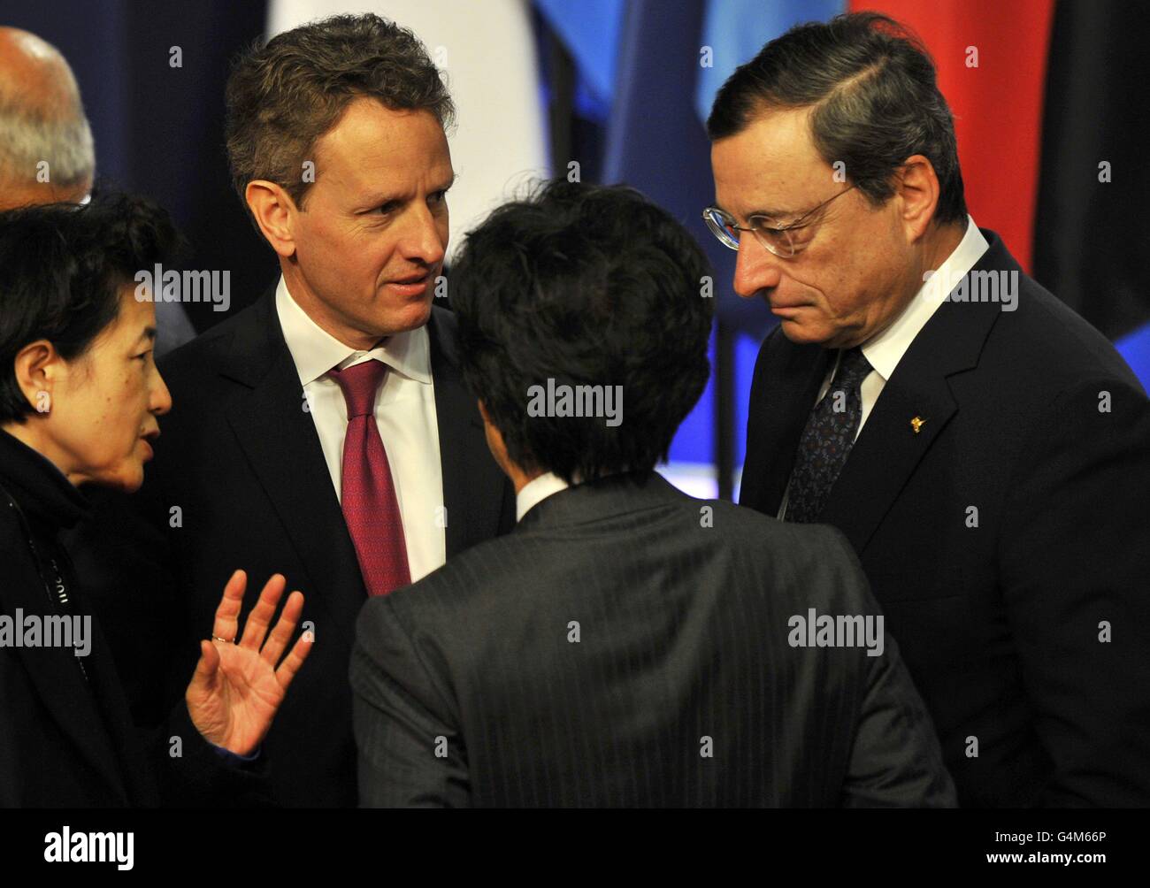 Ein Dolmetscher (links) übersetzt als US-Finanzminister Timothy Geithner (zweite links) Japans Finanzminister Jun Azumi (Mitte) und der Präsident der Europäischen Zentralbank (EZB) Mario Draghi (R) sprechen nach einem Familienfoto der G20-Finanzminister am zweiten Tag des G20-Gipfels in Cannes, Frankreich heute. Stockfoto