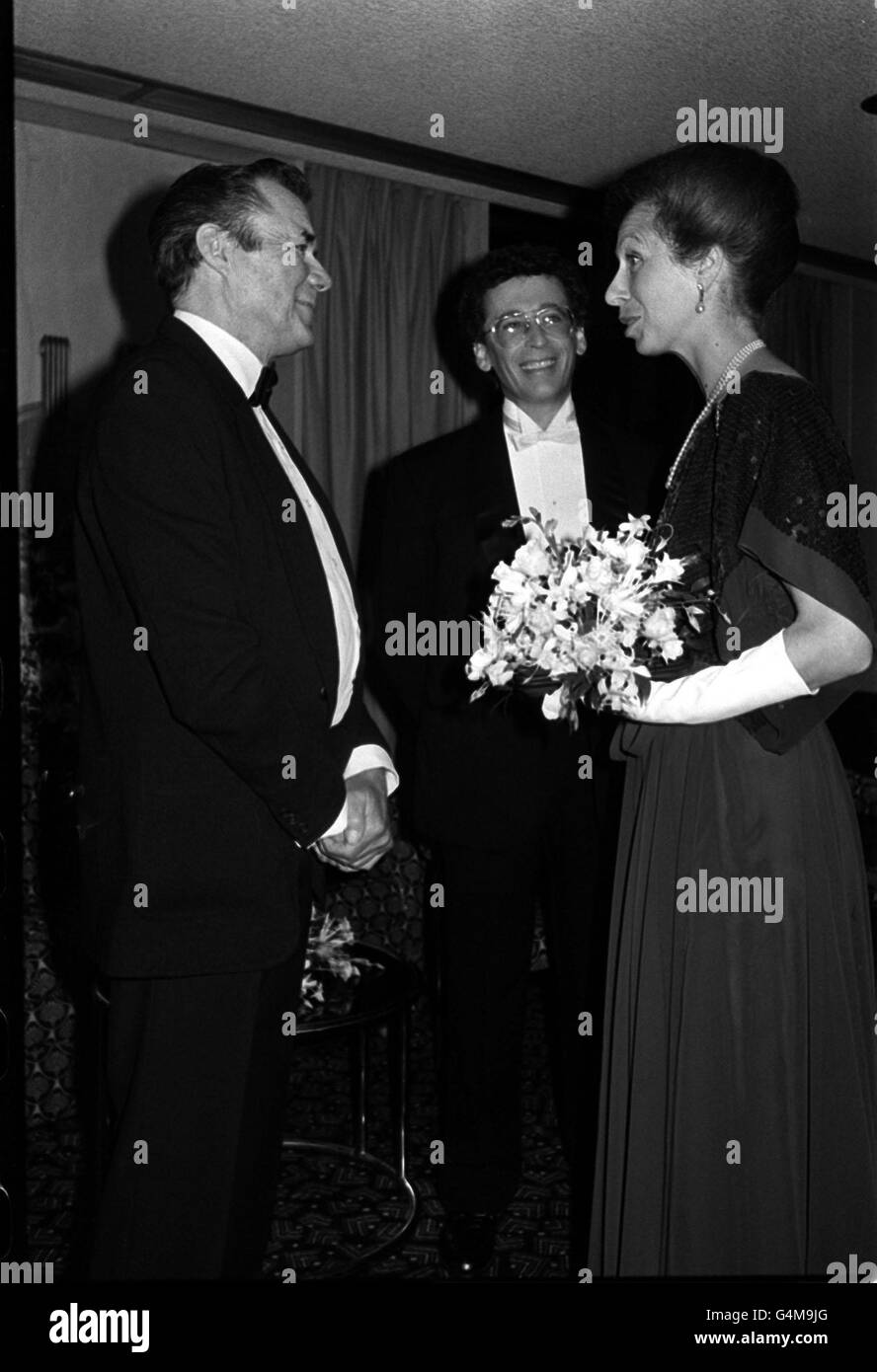 Sir Dirk Bogarde trifft die Prinzessin Royal auf dem Odeon am Leicester Square, wo sie ihm einen BAFTA-Preis für wichtige Beiträge zum Weltkino überreichte. Schauspieler Robert Powell schaut zu. Sir Bogarde starb am 8. Mai 1999 im Alter von 78 Jahren. Stockfoto