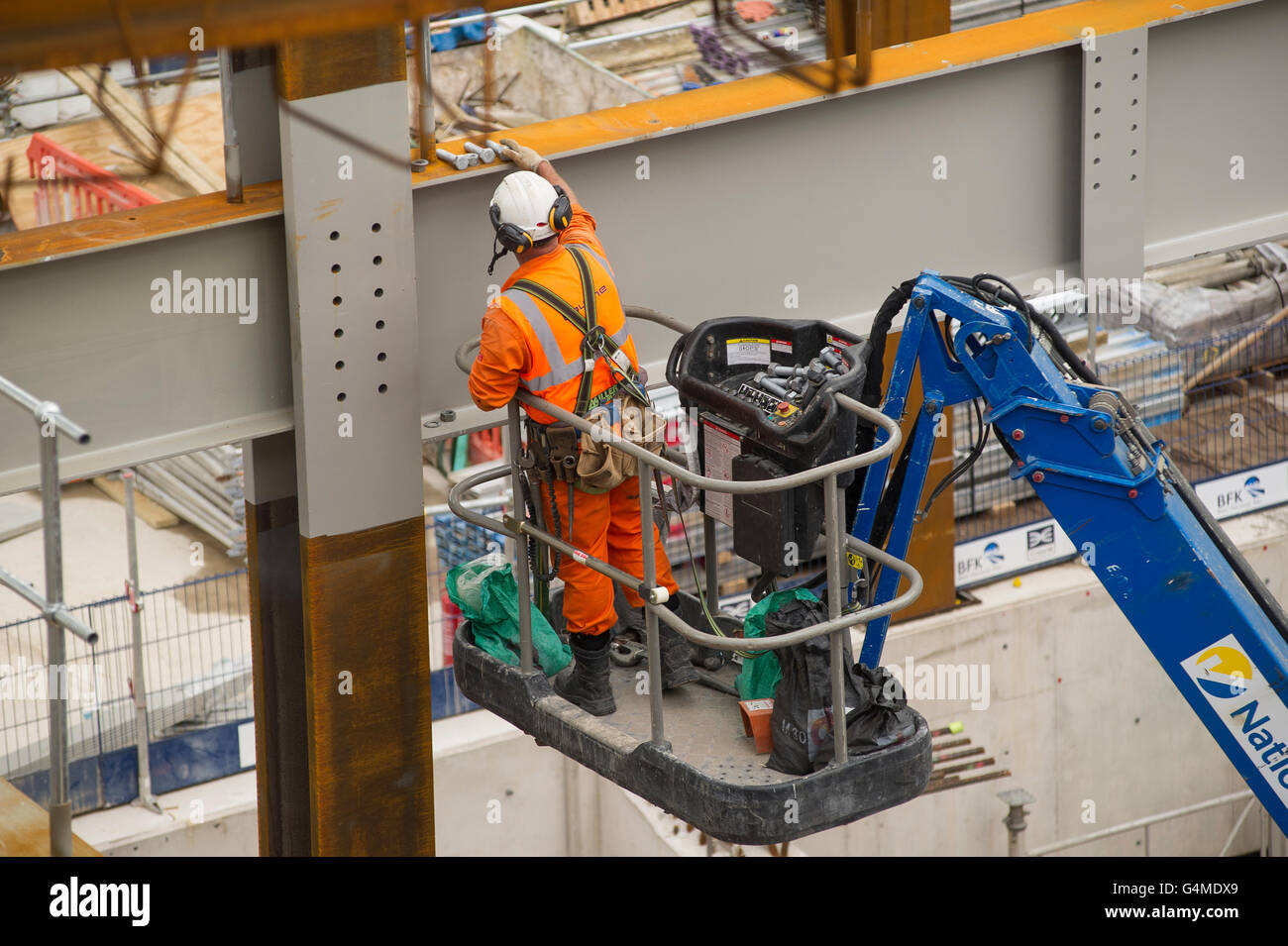 Bauarbeiter mit einem Hebezeug Träger auf der östlichen Schalterhalle Website unter Crossrail-Bahnhof Farringdon, London zu installieren Stockfoto