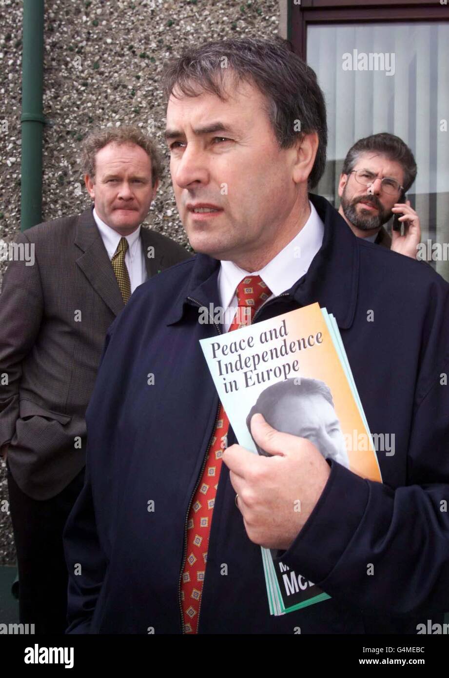 Sinn Fein-Sprecher Martin McGuinnness (links) und Präsident Gerry Adams (rechts) sehen sich an, wie der Vorsitzende von Sinn Fein, Mitchell McLaughlin, während seines Wahlkampfs zum Europäischen Parlament mit den Medien spricht. Stockfoto